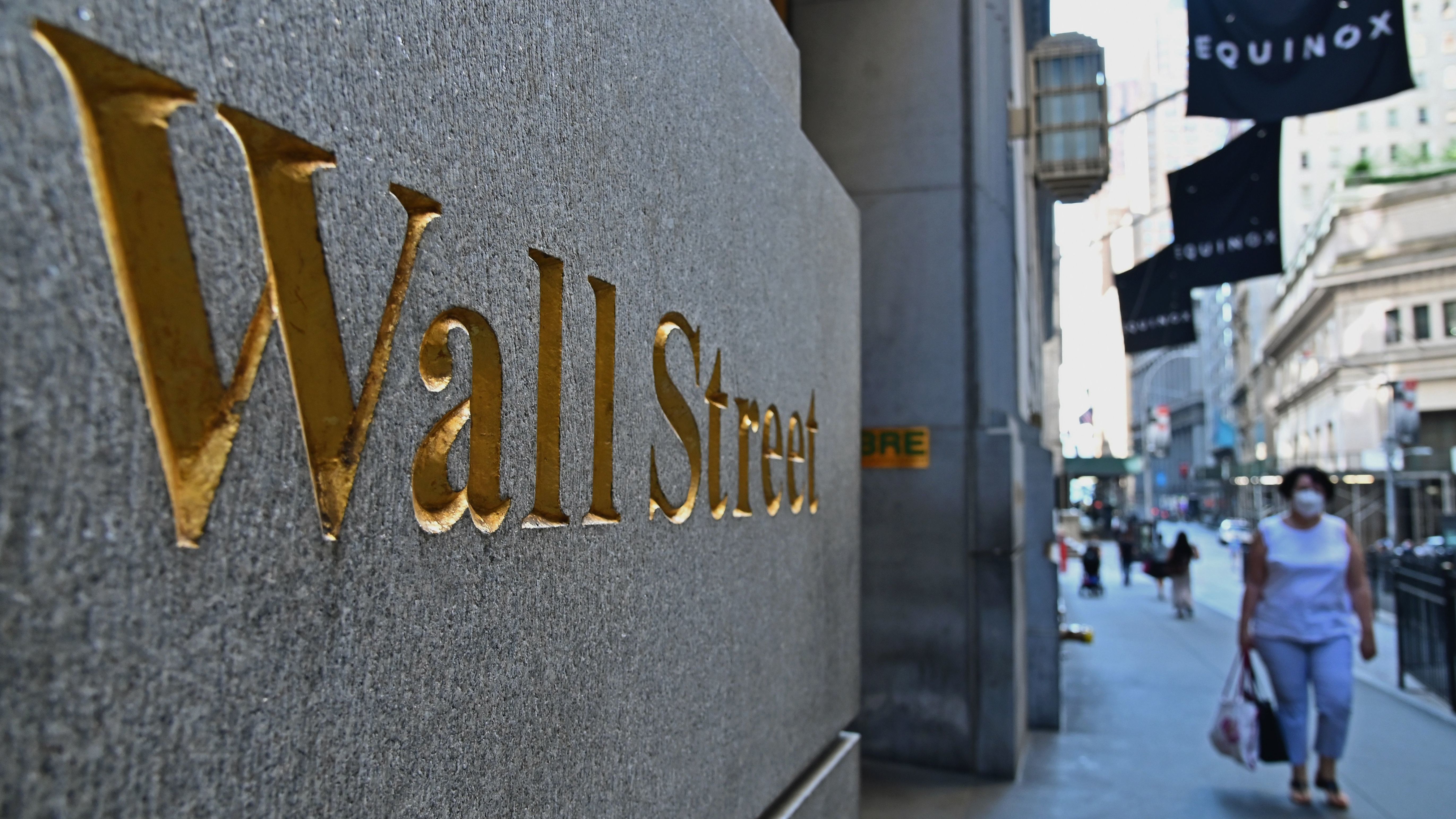 People walk near the New York Stock Exchange in June. The S&P 500 index has fully recovered from its plunge earlier this year when the pandemic began shutting down much of the economy. (AFP via Getty Images)