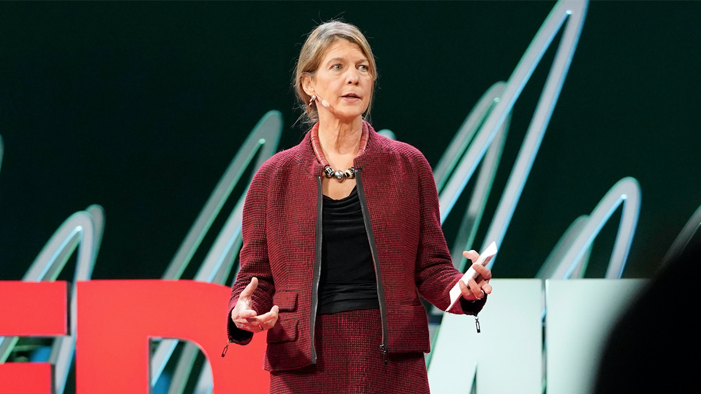 Heidi Larson speaks from the TED stage.