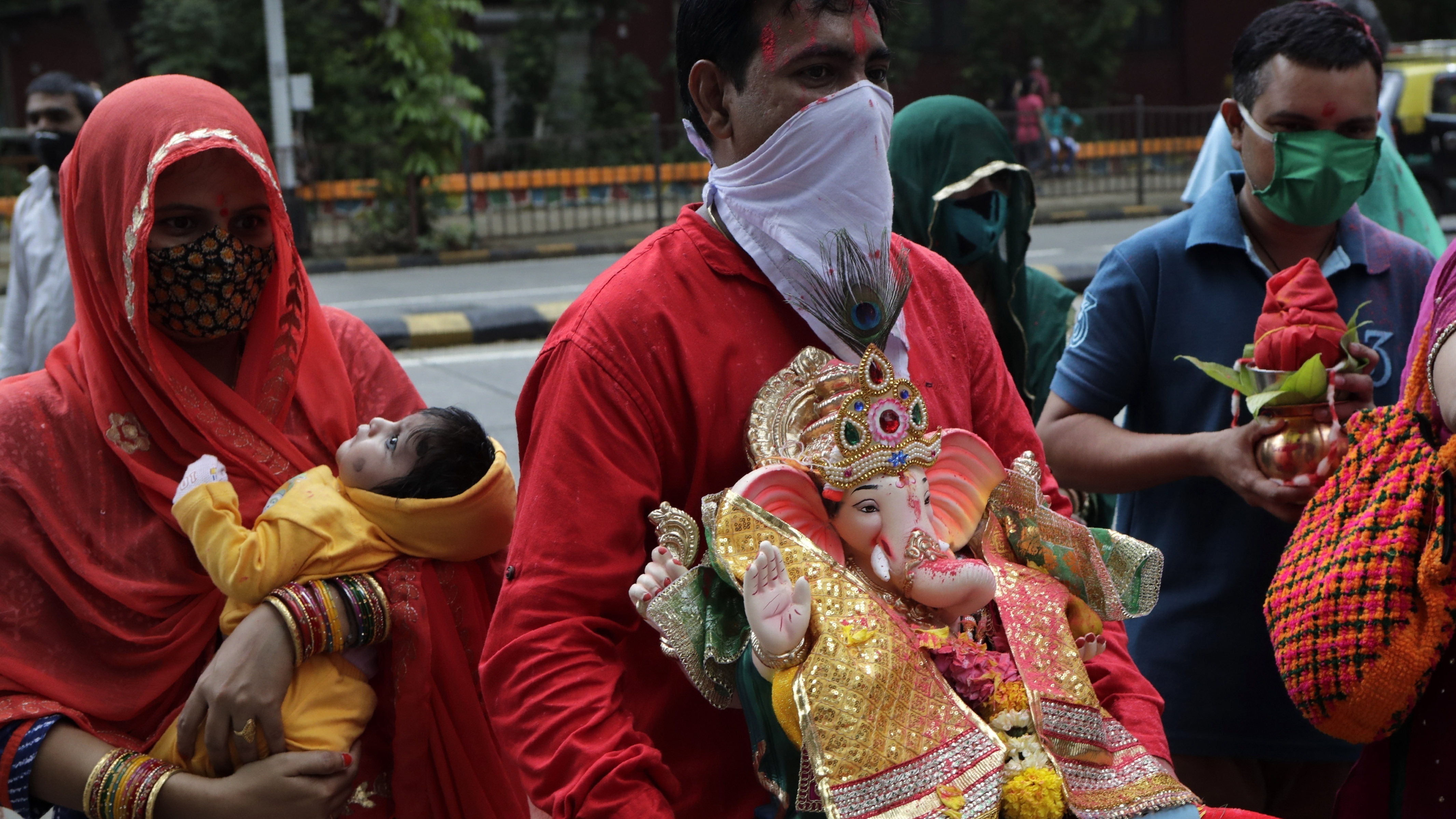 Devotees prepare to immerse in an artificial pond an idol of elephant-headed Hindu god Ganesh in Mumbai, India, Aug. 23. India