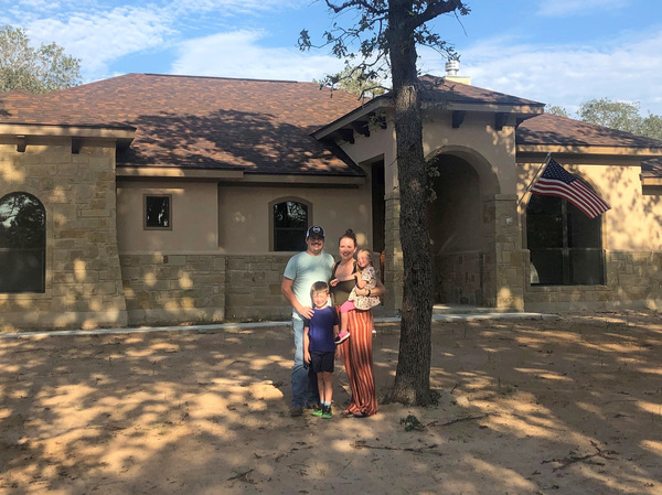 Caroline Wells and her family at their new home outside San Antonio. The builders just finished it so the yard has yet to be planted, but the couple is looking forward to letting the kids run out their energy with a lot more outdoor space than they had at their previous home in the city.