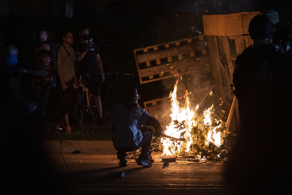 A protester in Kenosha lights some debris on fire on Aug. 26, 2020. (Angela Major/Angela Major/WPR)