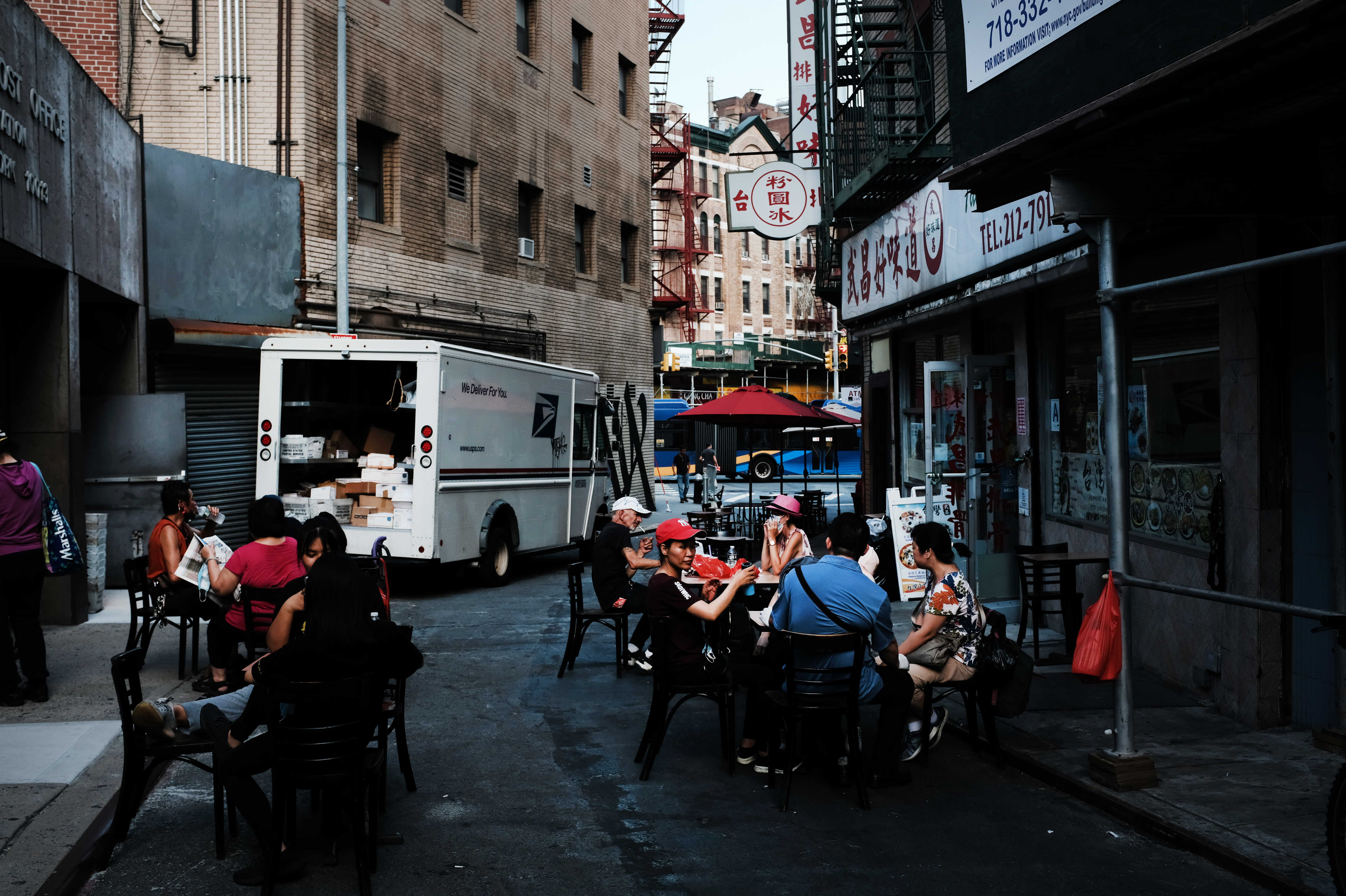 People eat in an outdoor dining area in New York City's Chinatown on Aug. 10. Economists warn spending may suffer this month. (Getty Images)