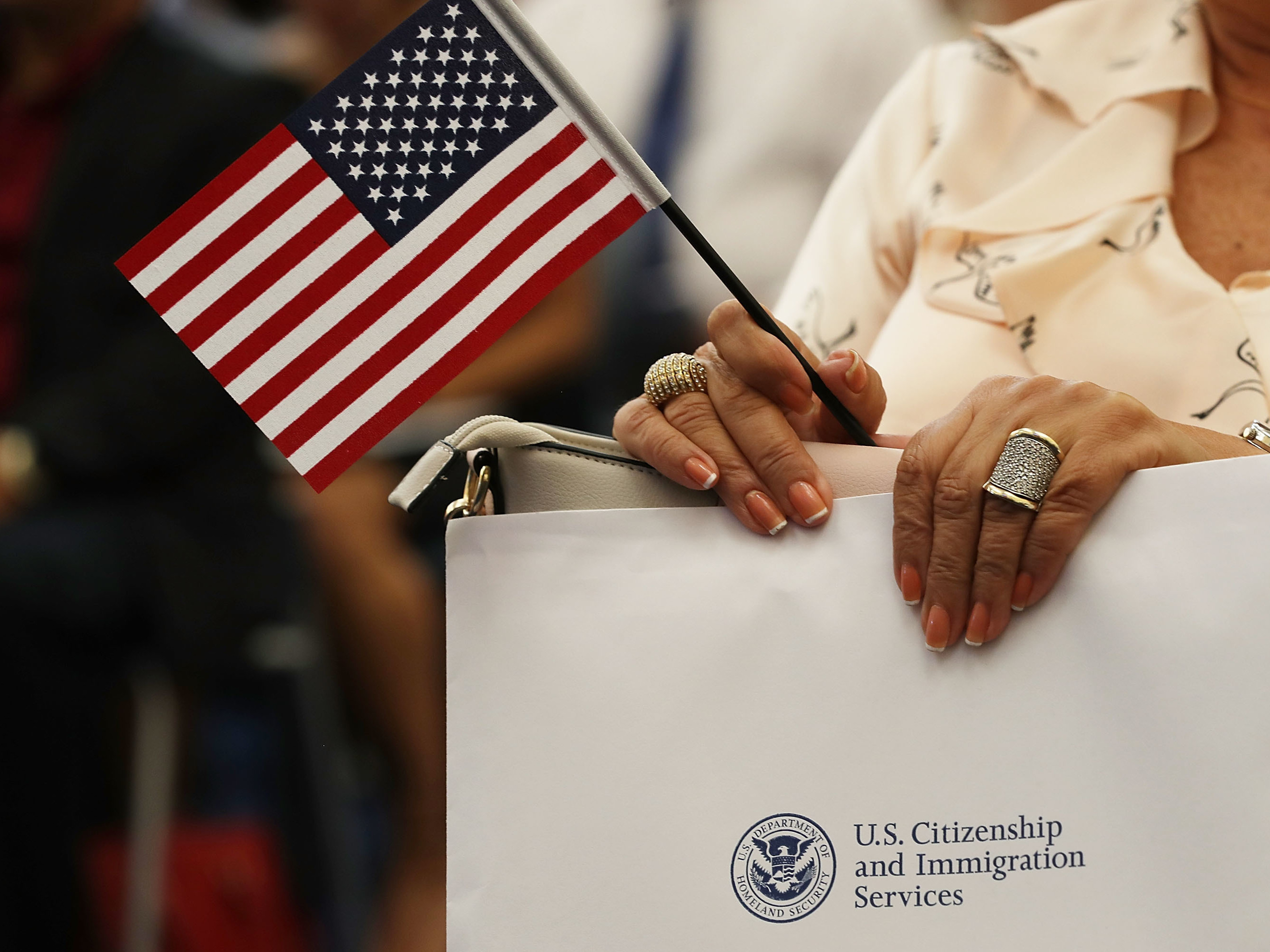 An attendee holds an American flag at a U.S. Citizenship & Immigration Services naturalization ceremony in Miami, Fla. in Aug. 2018. The Trump administration is considering expanding its collection of biometric data as part of the immigration process. (Getty Images)