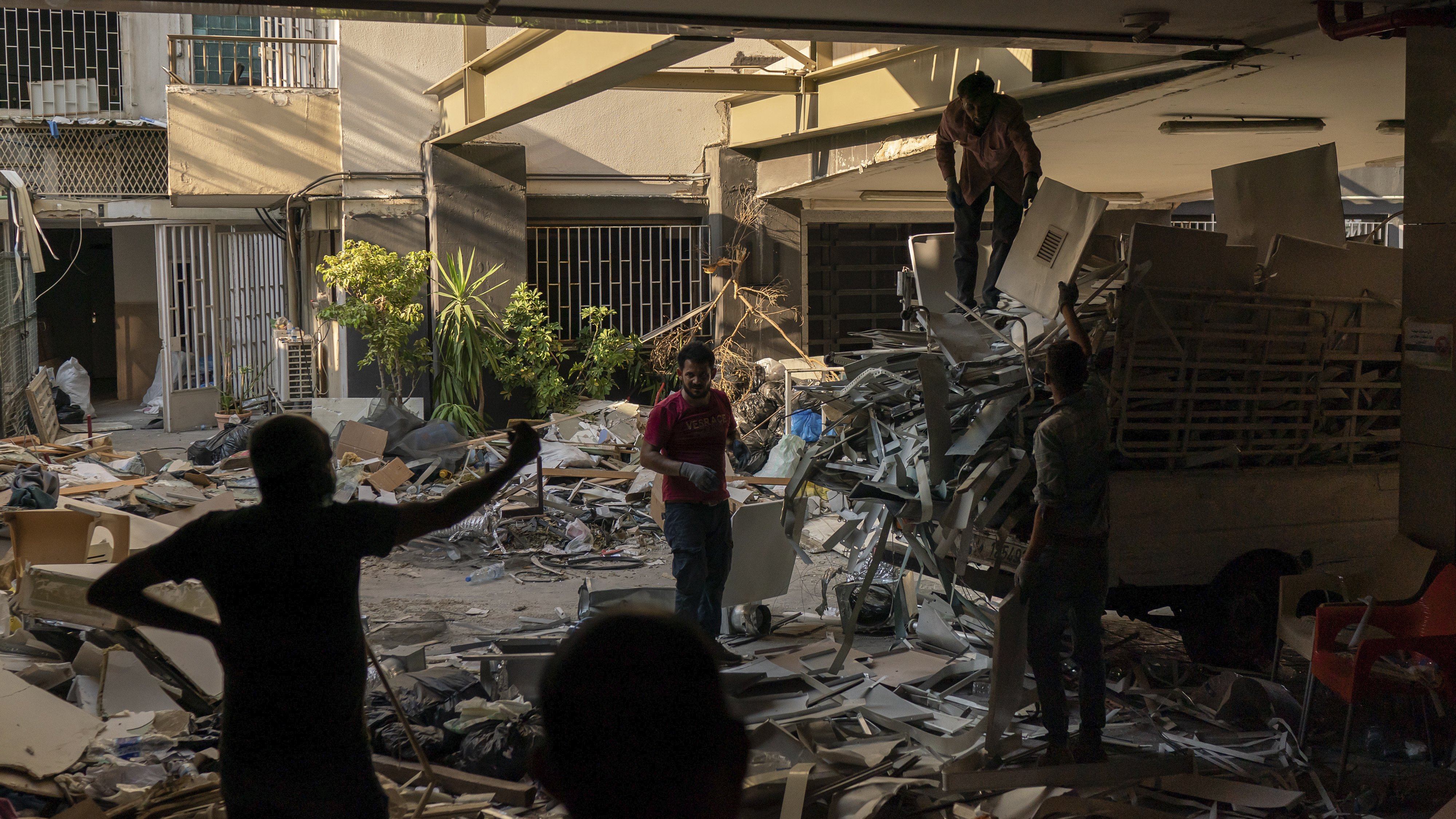 Workers remove debris from a hospital that was heavily damaged in last month