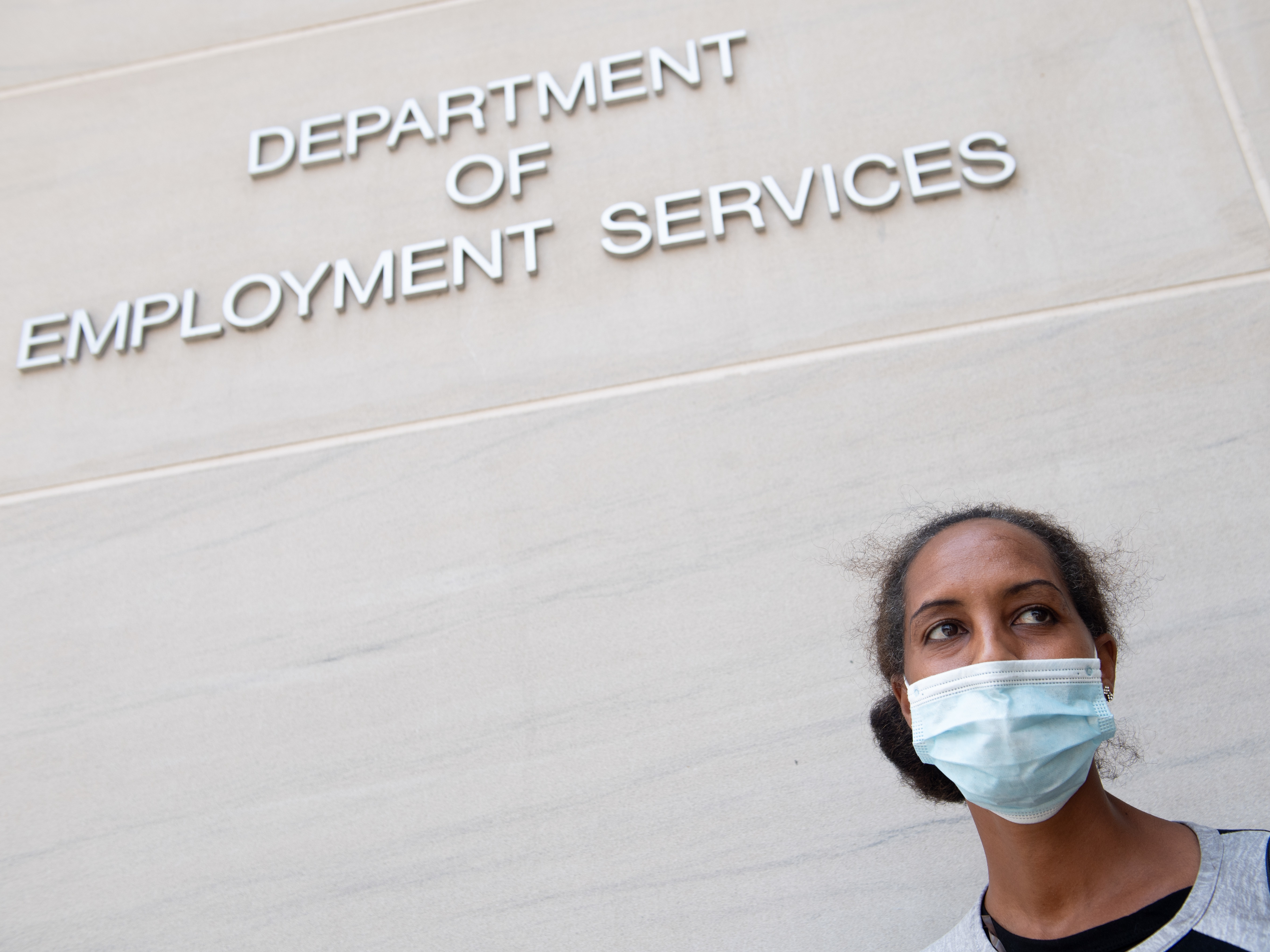 Diana Yitbarek seeks information about her unemployment claim in Washington, D.C., in July. Applications for jobless benefits nationwide have been dropping but remain very high by historical standards. (AFP via Getty Images)