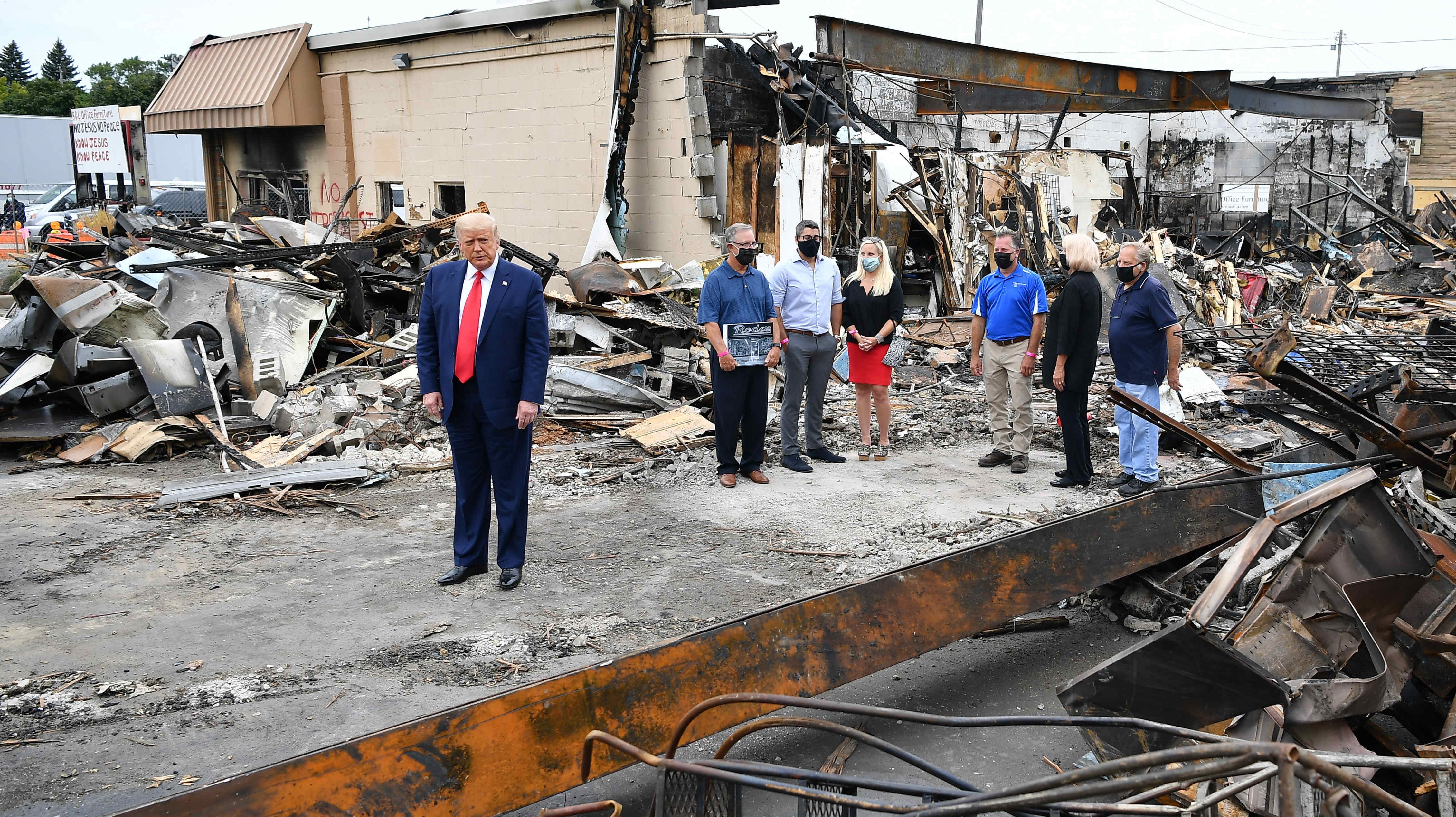 President Trump tours an area affected by civil unrest in Kenosha, Wis., on Tuesday. While there, he attacked Democratic leaders in other nearby big cities, saying they aren't doing enough on crime. (AFP via Getty Images)