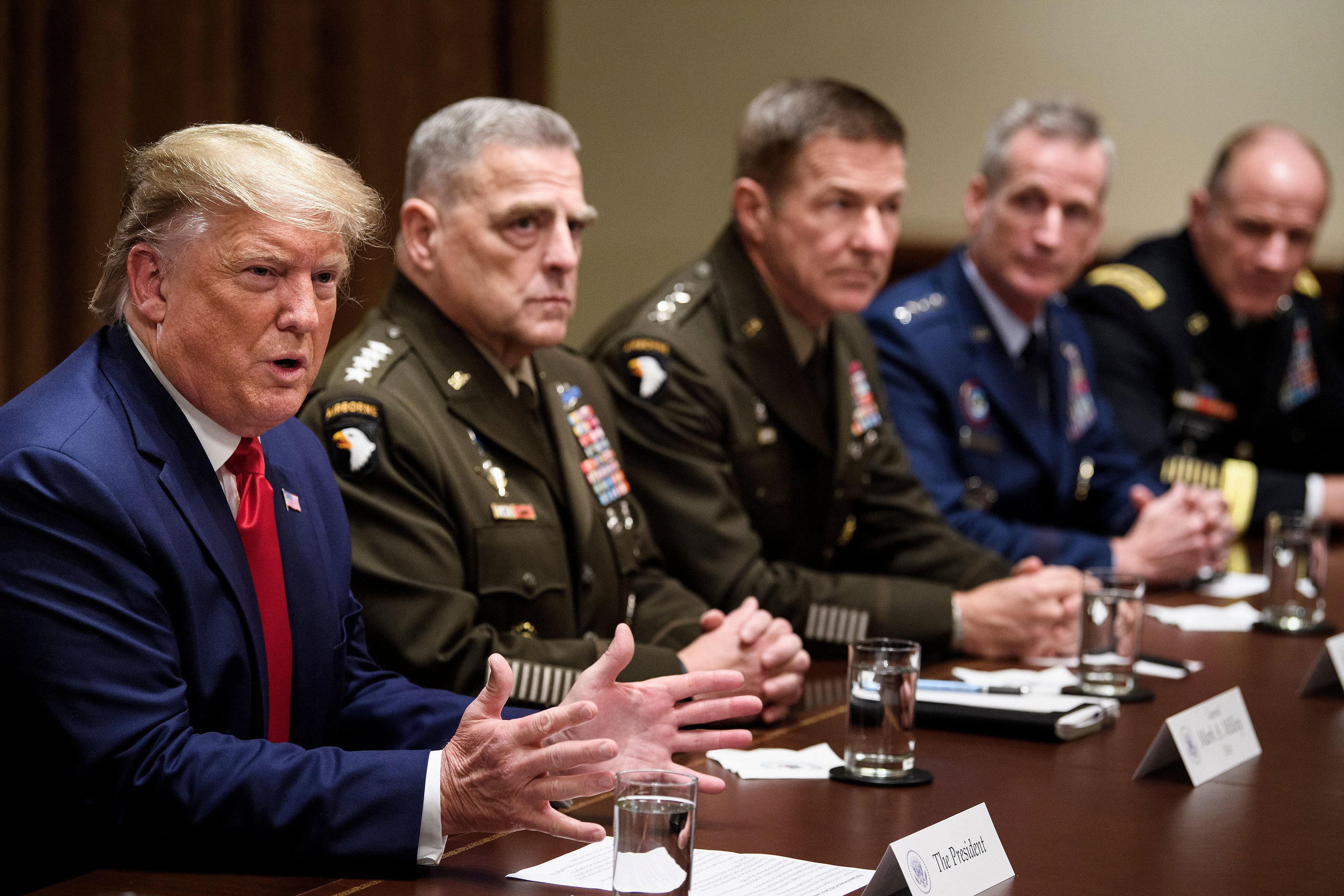 Army Gen. Mark Milley (second from left), chairman of the Joint Chiefs of Staff, and others listen as President Trump speaks during a meeting with senior military leaders in October. (AFP via Getty Images)