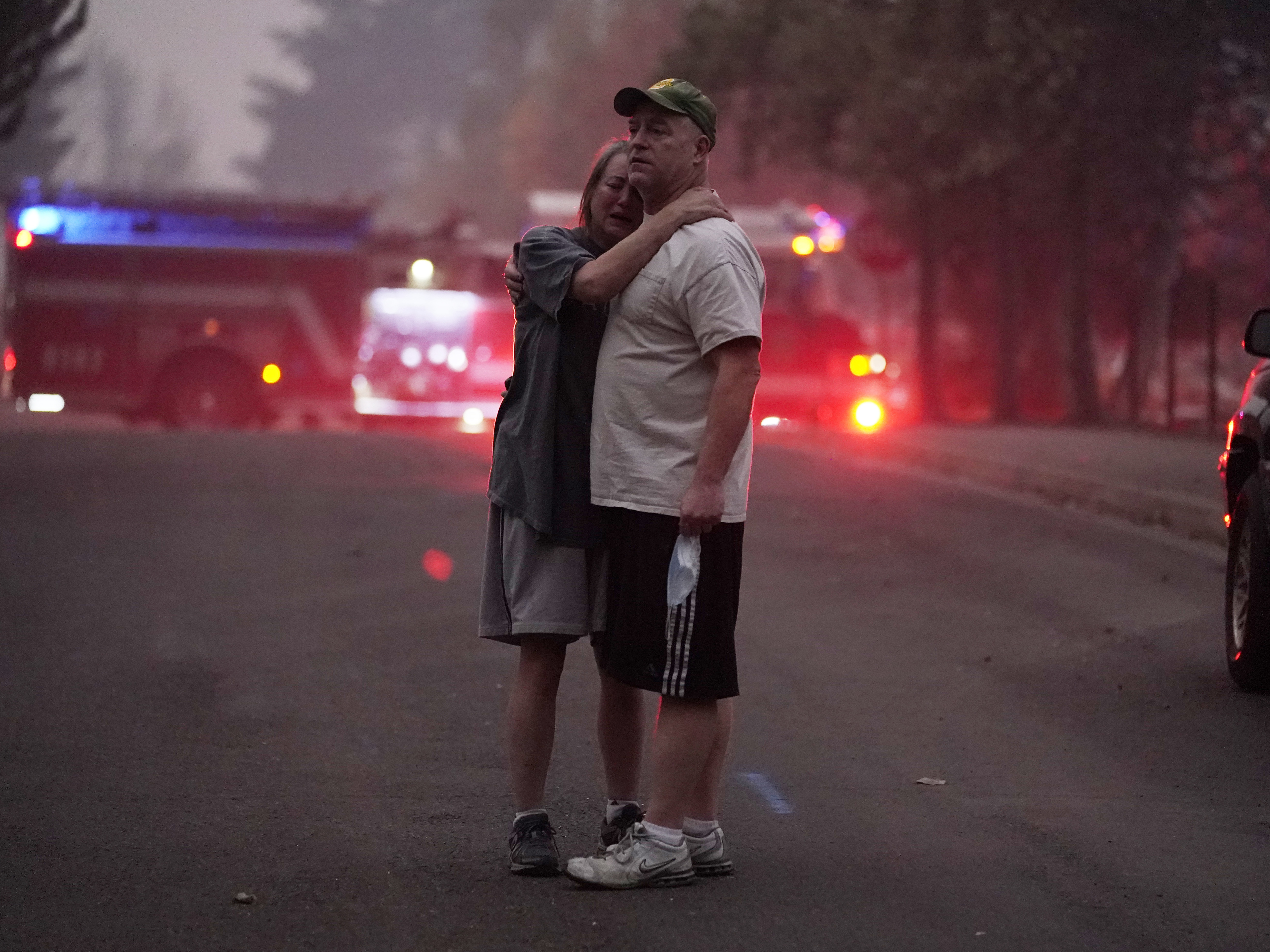 A couple embrace Thursday while touring an area devastated by the Almeda Fire in Phoenix Ore