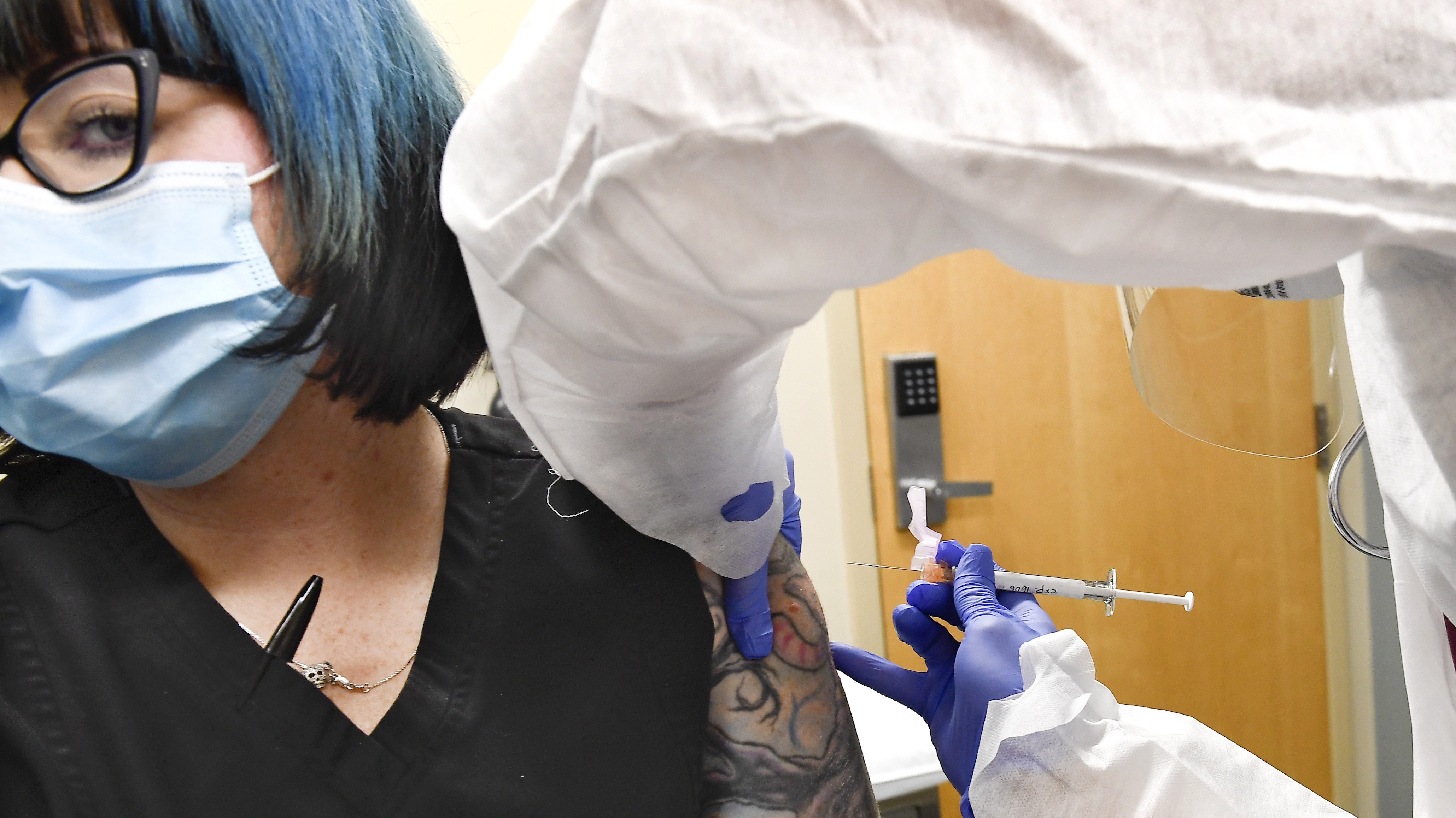 Nurse Kathe Olmstead, right, gives volunteer Melissa Harting, of Harpersville, N.Y., an injection in a study of a possible COVID-19 vaccine, developed by the National Institutes of Health and Moderna Inc.