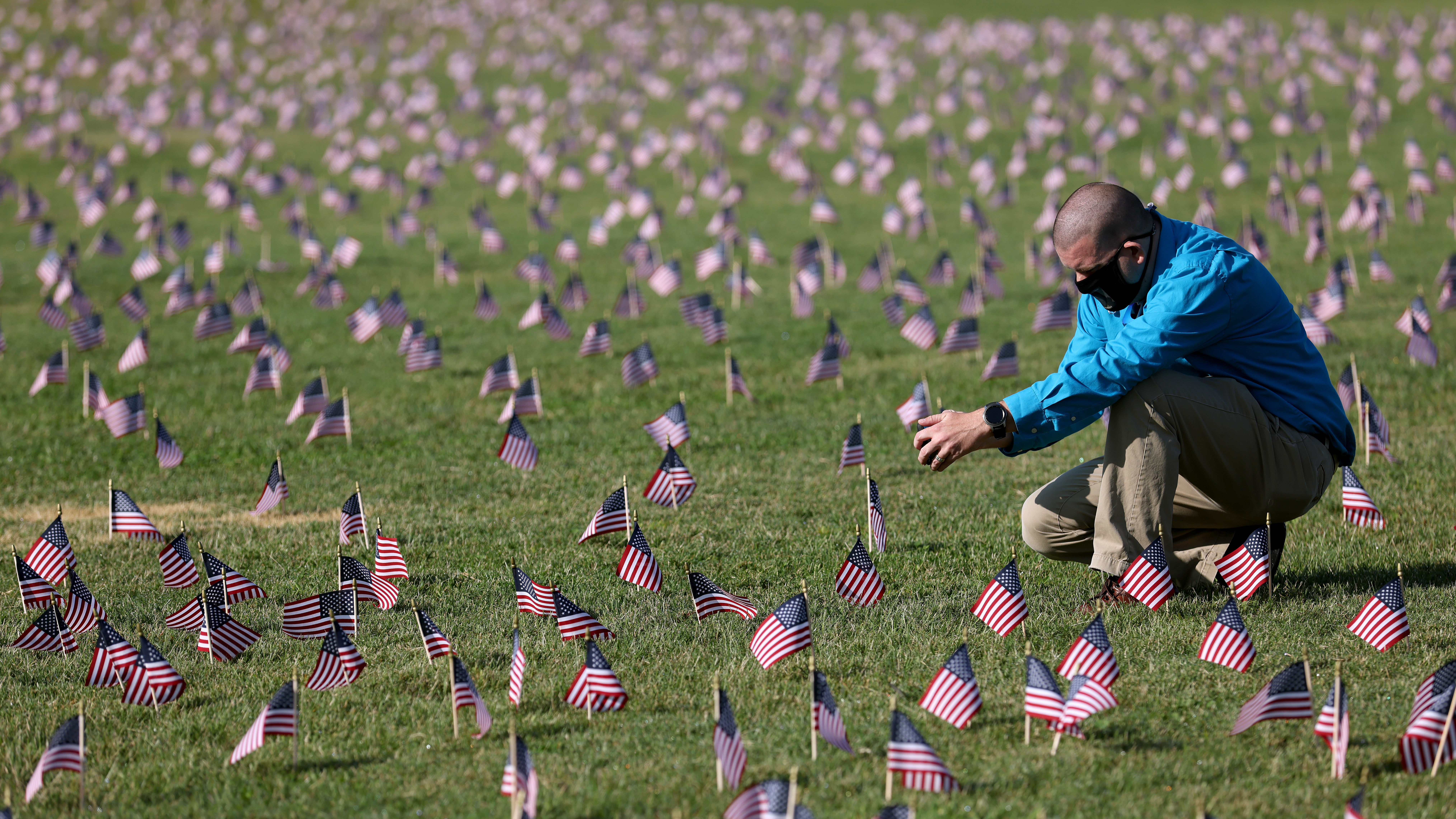 The U.S. hit a tragic milestone Tuesday, recording more than 200,000 coronavirus deaths. Here, Chris Duncan, whose 75-year-old mother, Constance, died from COVID-19 on her birthday, visits a COVID Memorial Project installation of 20,000 U.S. flags on the National Mall. The flags are on the grounds of the Washington Monument, facing the White House. (Getty Images)