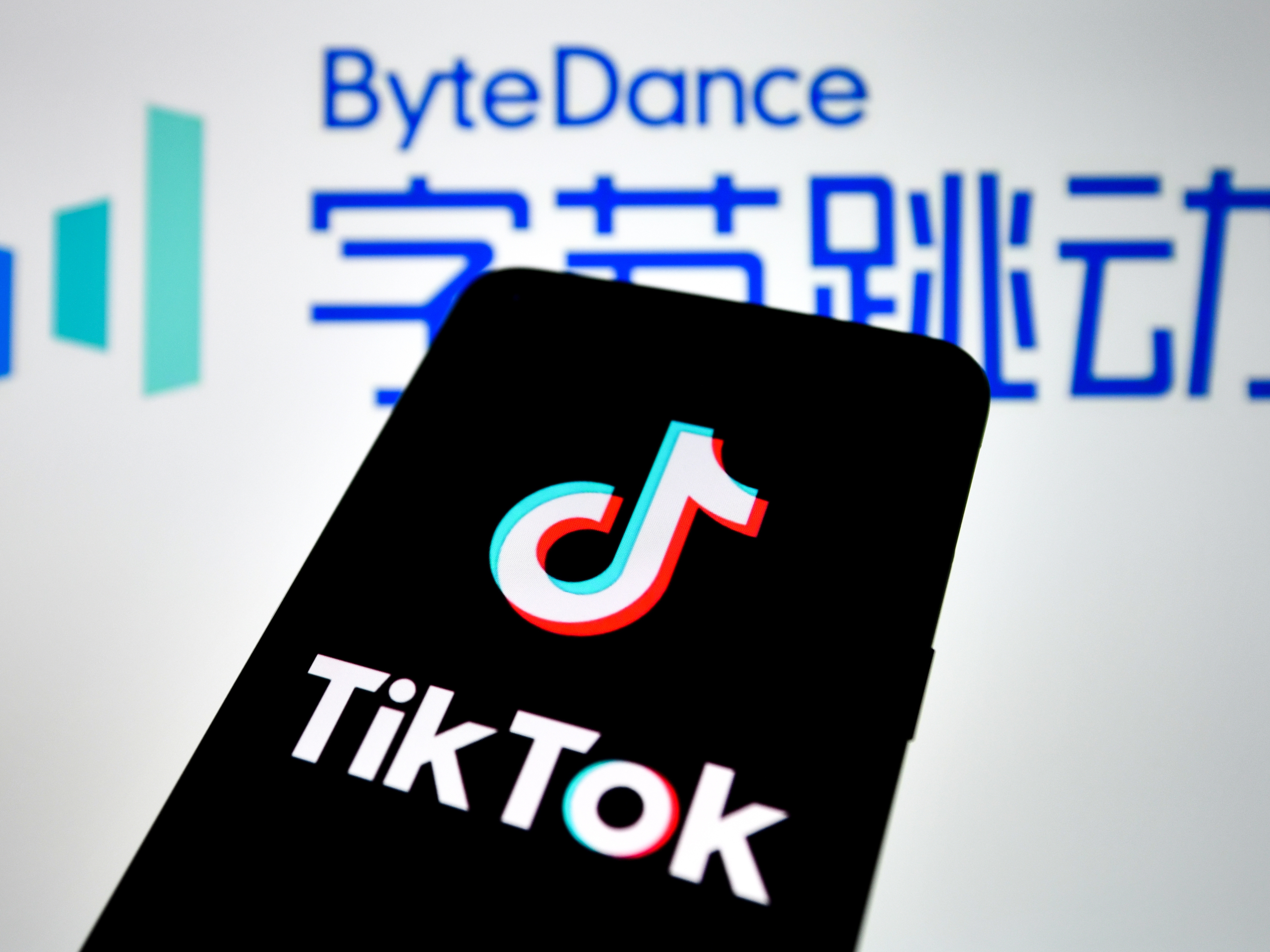 In this photo illustration, a TikTok logo seen displayed on a smartphone with a ByteDance logo picture in the background. (SOPA Images/LightRocket via Getty Images)