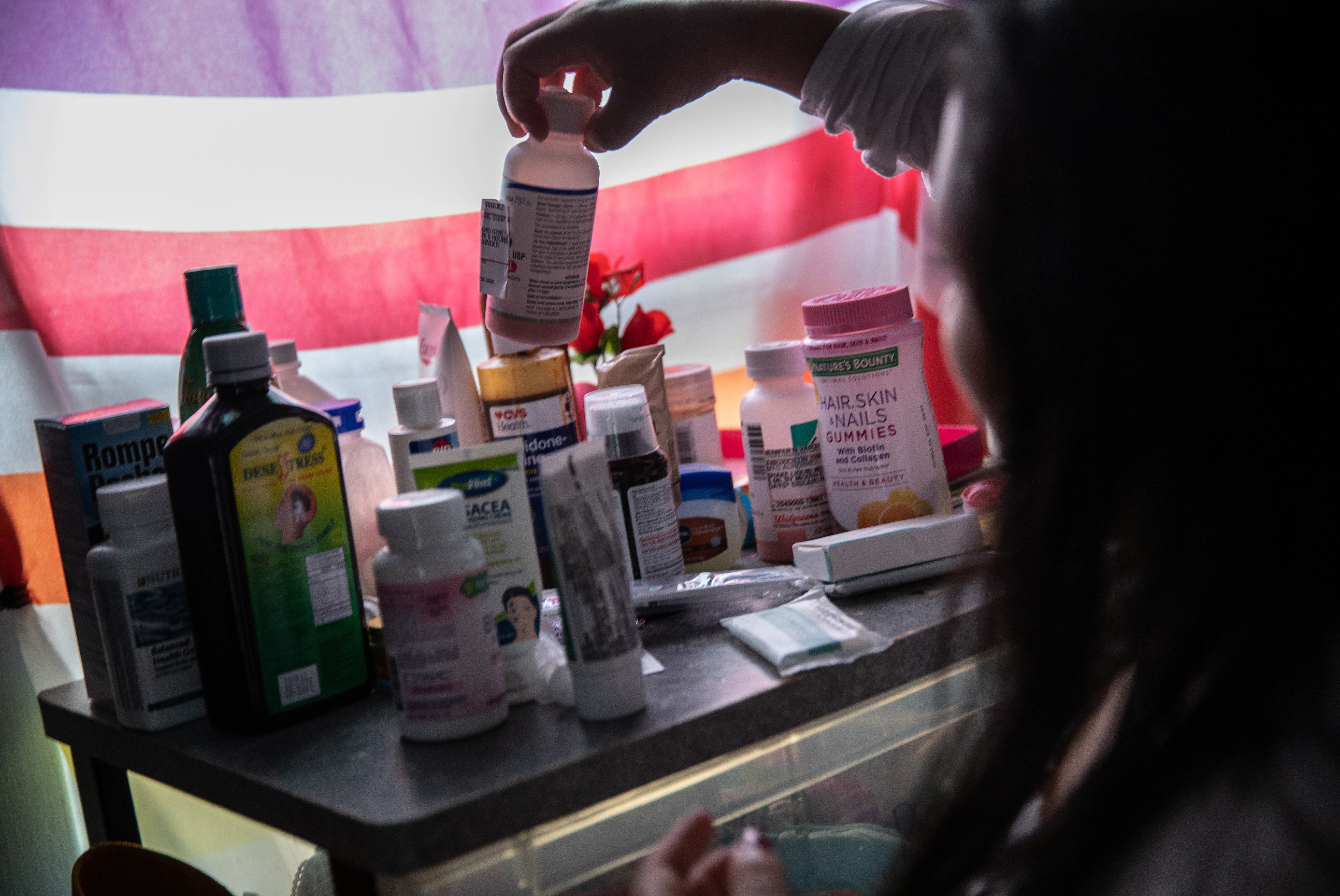 A woman recovering from fever linked to COVID-19 checks medications in her home in Mineola, N.Y., this spring. (Getty Images)