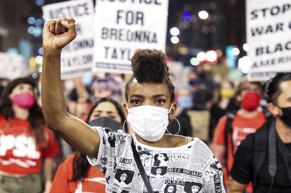 Sheree Barbour holds her fist in the air in Denver, Colo. as people protest the grand jury decision in the Breonna Taylor case.