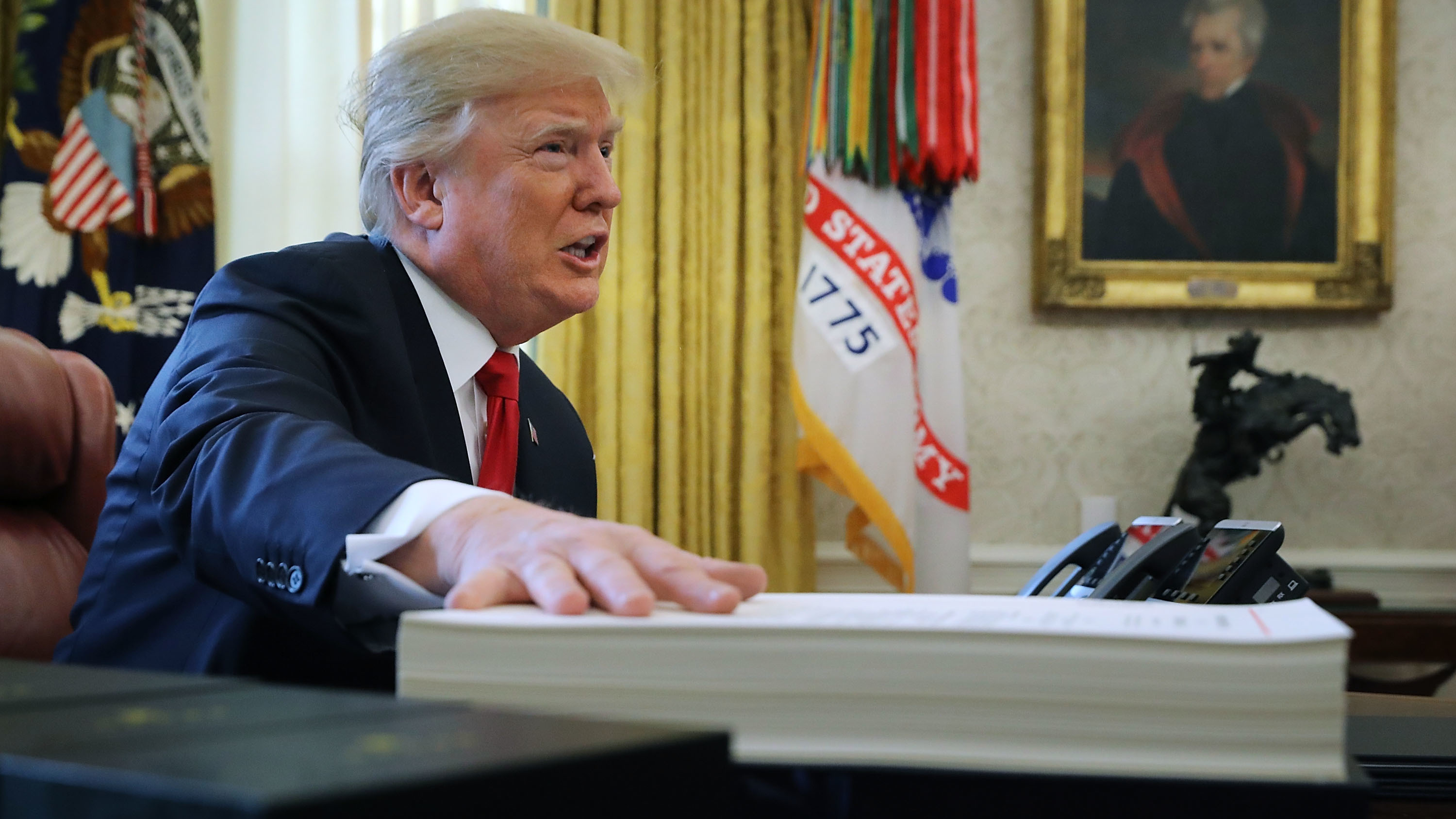 Analysts say real estate tax breaks allowed President Trump to personally avoid high taxes. Above, Trump prepares to sign tax legislation into law in the Oval Office on Dec. 22, 2017.