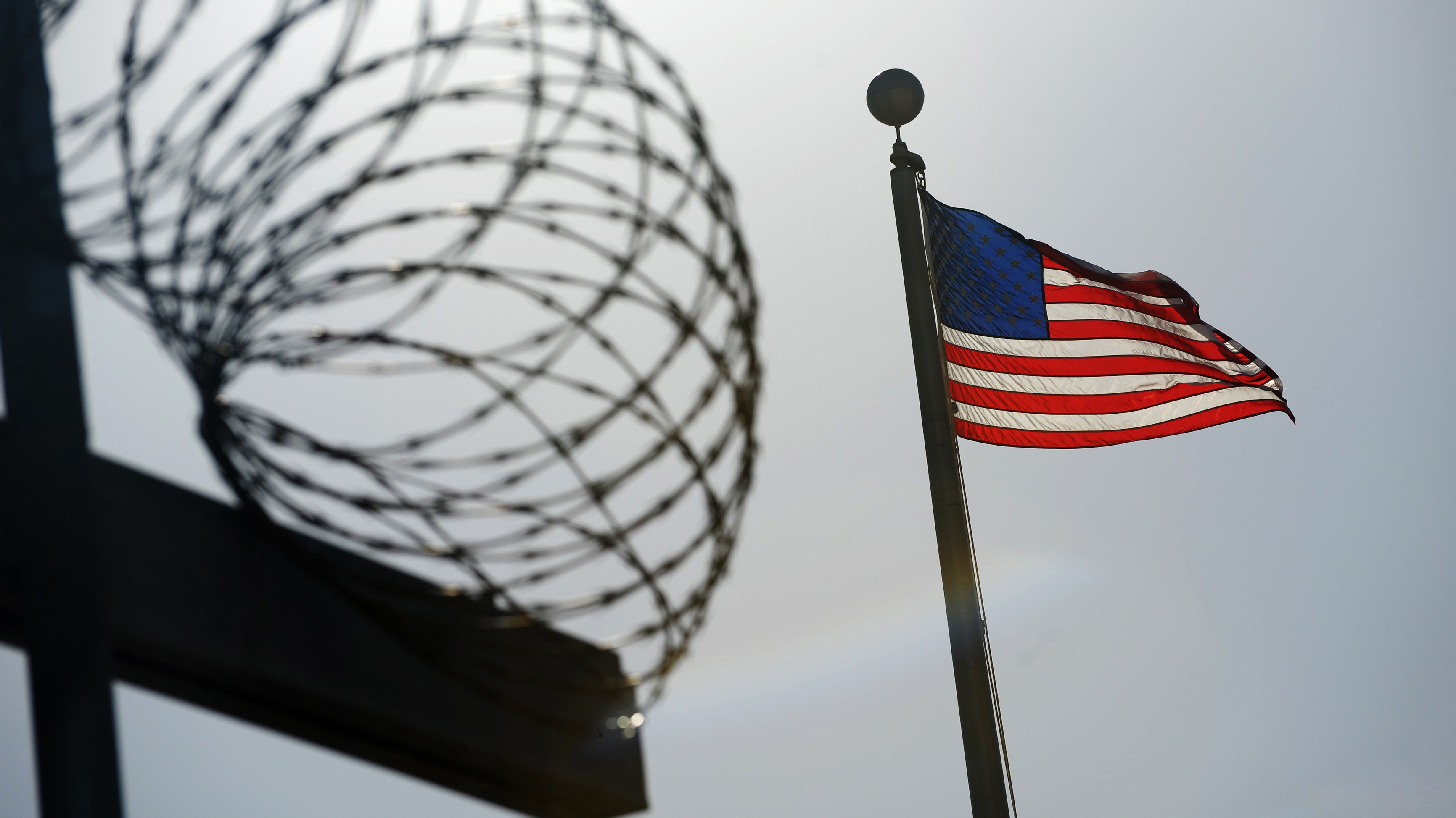 A U.S. flag flies above a fence at the detention facility at the U.S. Naval Station at Guantánamo Bay, Cuba, on Dec. 10, 2008, in an image reviewed by the U.S. military.
