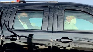 President Trump looks on from the back of a car in a motorcade outside of Walter Reed Medical Center in Bethesda, Maryland.