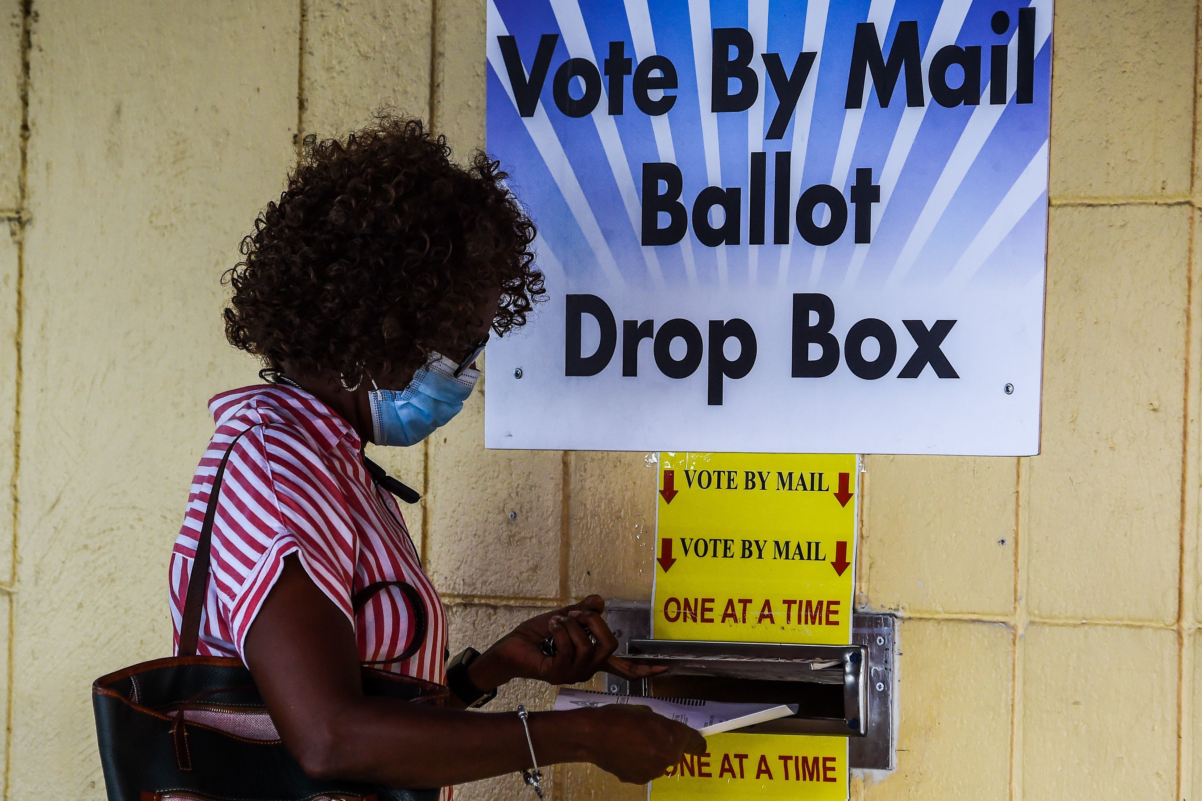 A woman drops her ballot by mail at Broward County Supervisor Of Elections Office in Lauderhill, Fla., on Monday. (AFP via Getty Images)