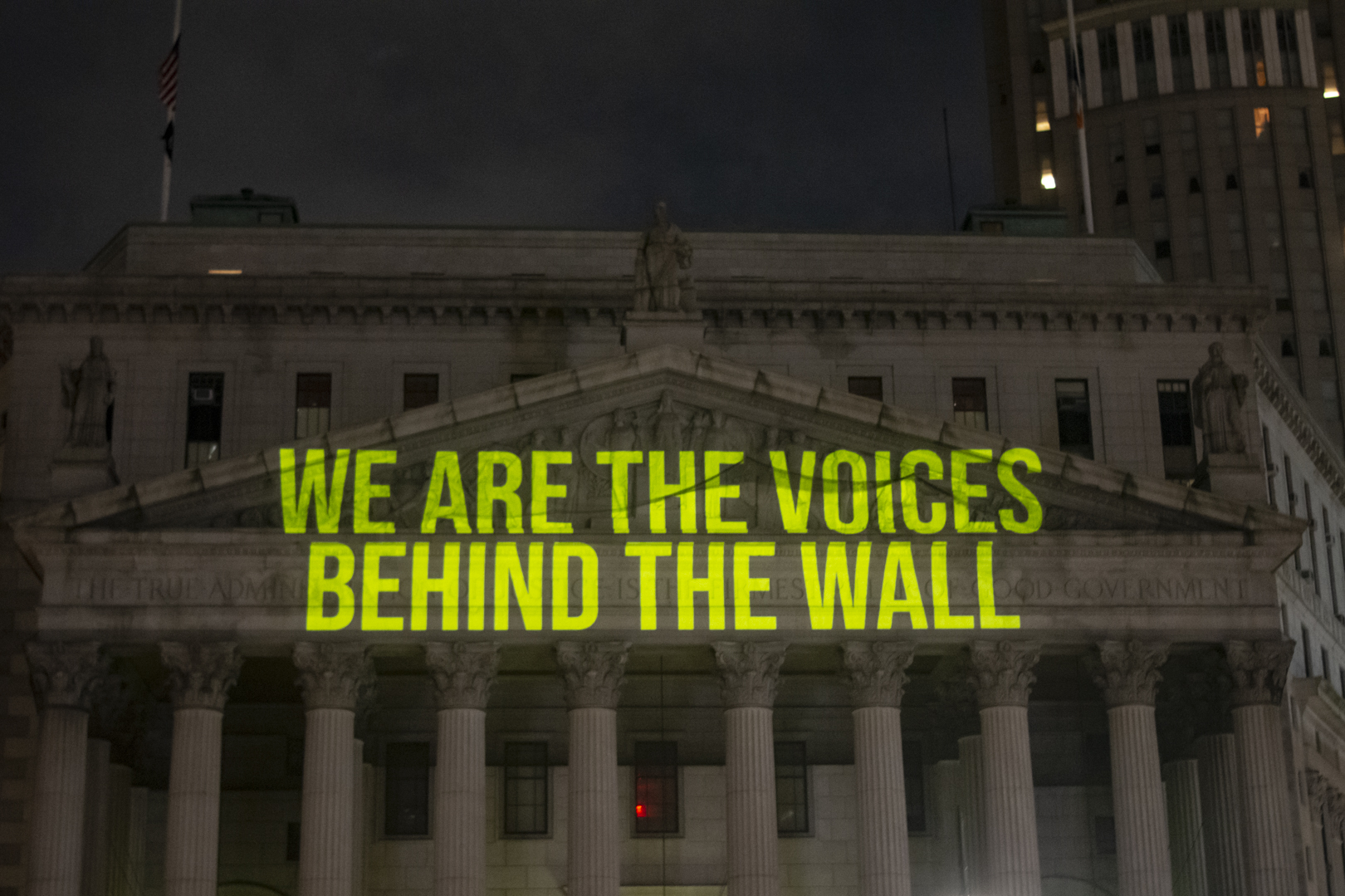 &quot;The Writing On The Wall&quot; art installation projects writings by incarcerated people onto the sides of buildings, such as The New York State Supreme Court Building, above. (Chemistry Creative)