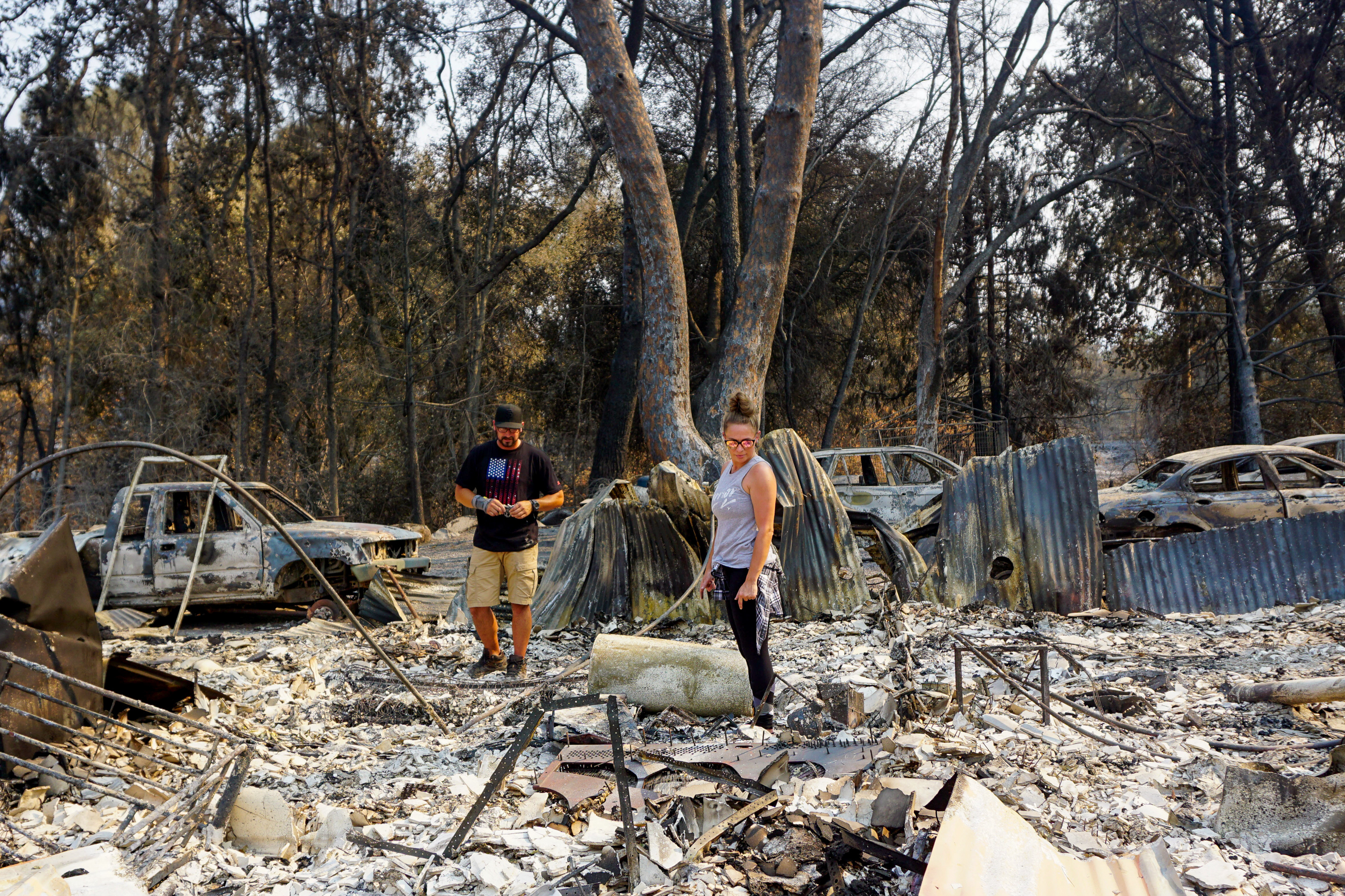 Ryan and Jennifer Montano search through the remains of their Vacaville, Calif., home, destroyed in the LNU Lightning Complex Fire in August. (NPR)