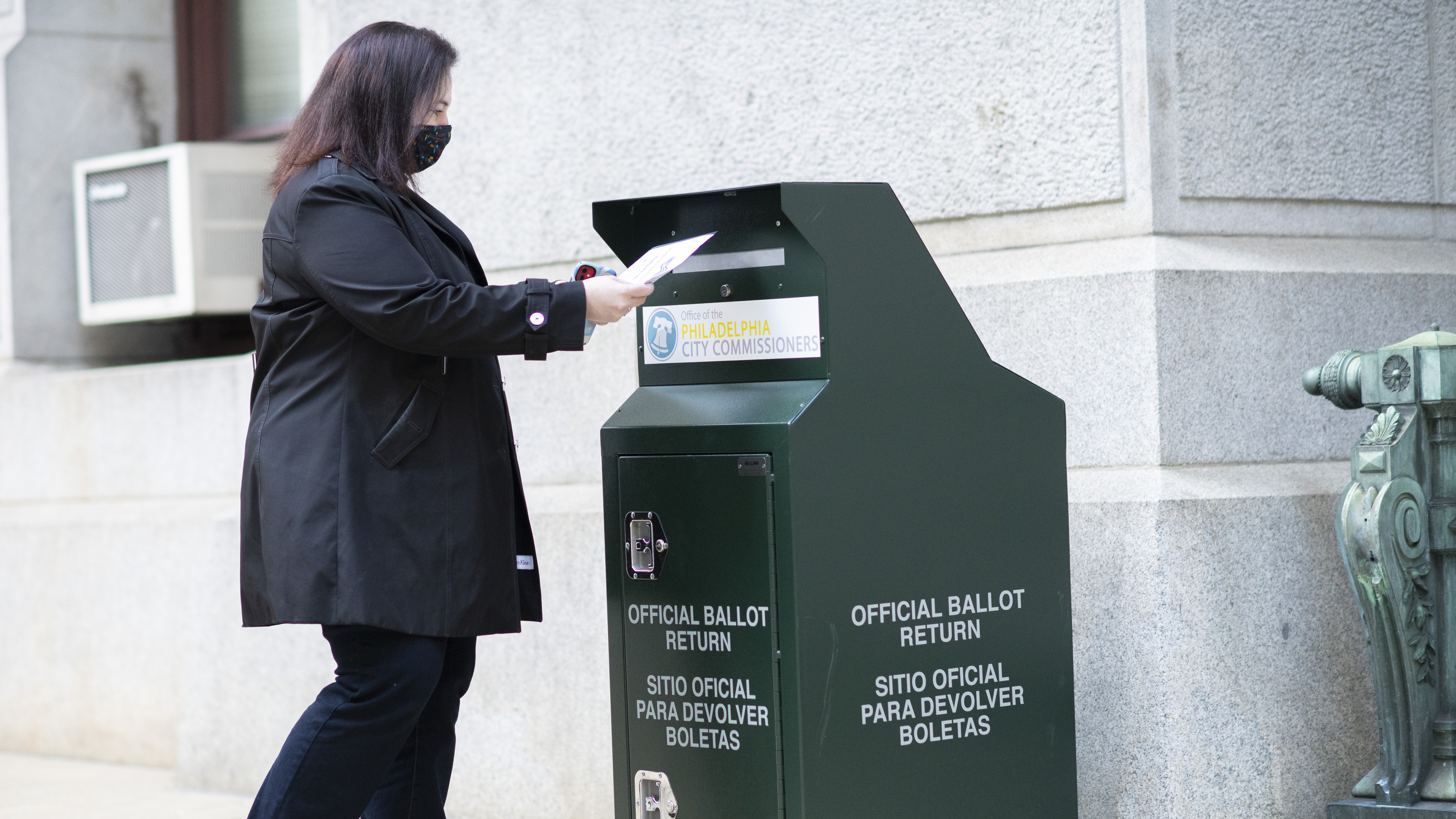 A voter casts her early voting ballot at drop box outside of City Hall on Oct. 17, 2020 in Philadelphia.