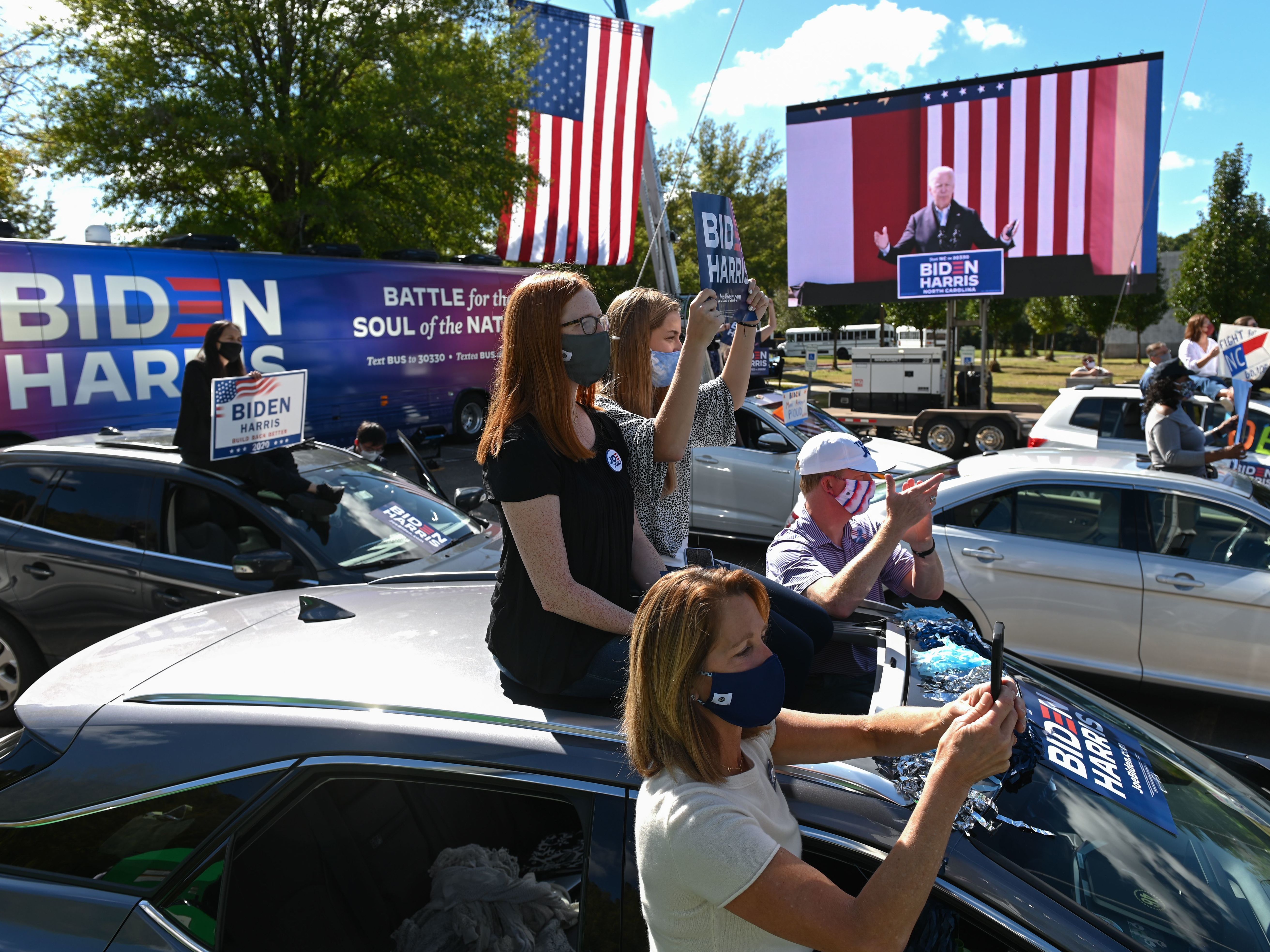 Supporters of Democratic presidential nominee Joe Biden sit atop their vehicles as they listen to him speak Sunday at Riverside High School in Durham, N.C. (AFP via Getty Images)