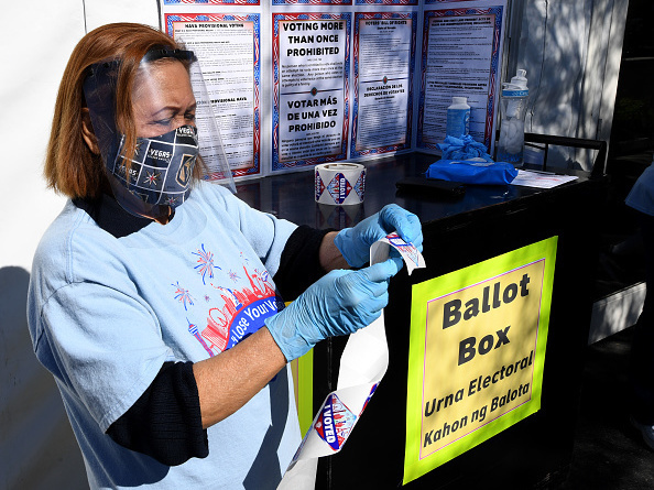 Volunteer Esmeralda Raymond gets a roll of "I Voted" stickers ready at a polling site in Las Vegas on the first day of in-person early voting on Oct. 17.