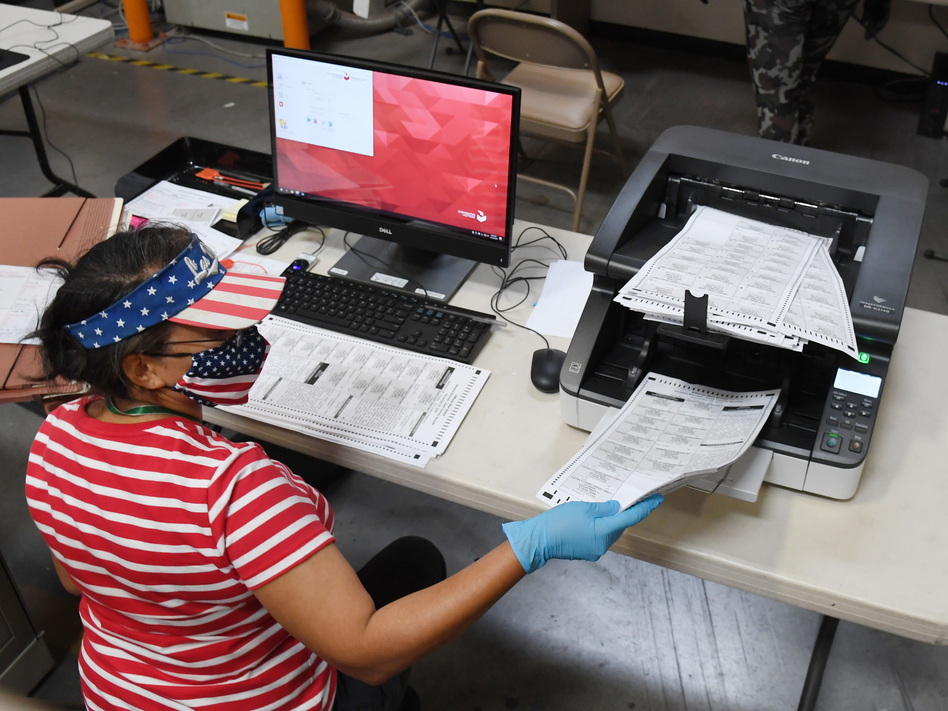 A Clark County, Nev., election worker scans mail-in ballots earlier this week in North Las Vegas. The state allows officials to count ballots received in advance of Election Day in order to speed the tabulation of results that evening. (Ethan Miller/Getty Images)
