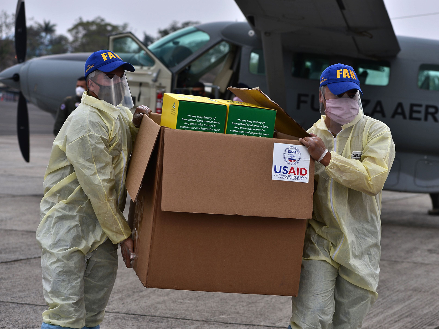 Foreign aid takes many forms — and Trump and Biden have differing perspectives. Above: Members of the Honduran Armed Forces carry a box of COVID-19 diagnostic testing kits donated by the United States Agency for International Development and the International Organization for Migration. (AFP via Getty Images)