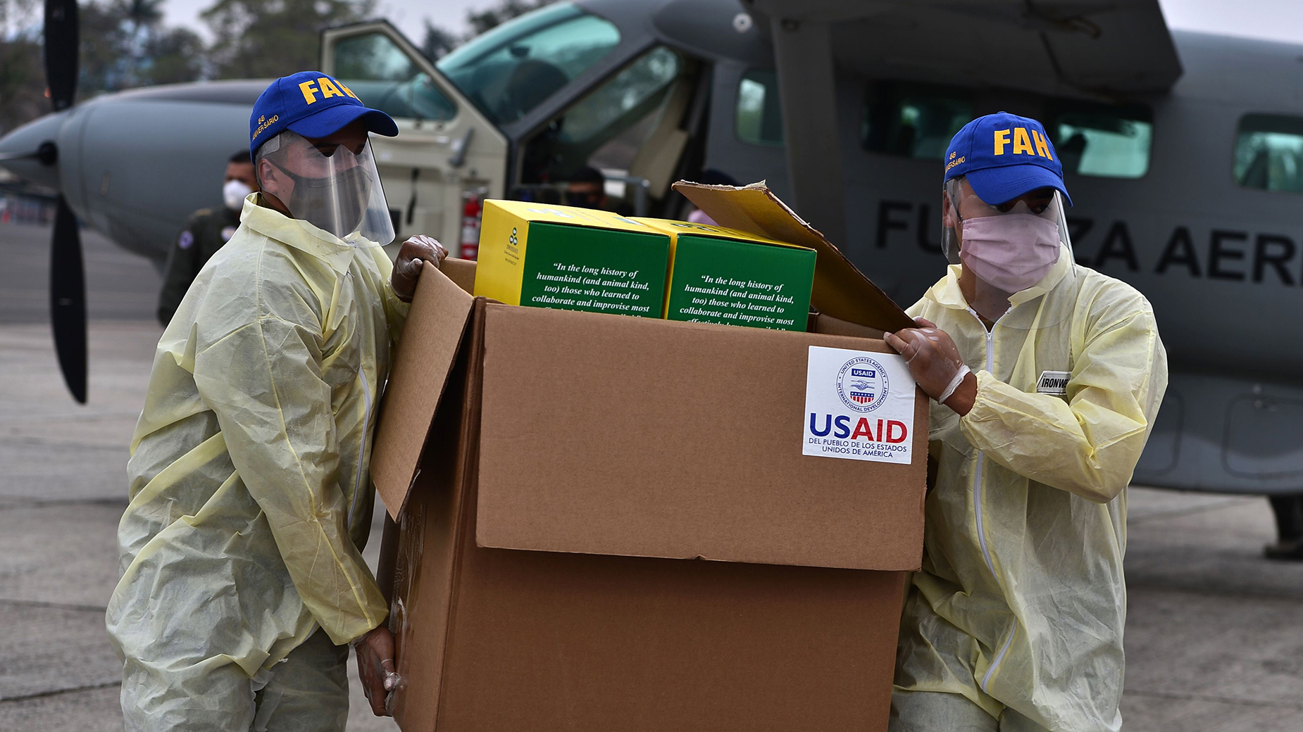 Foreign aid takes many forms — and Trump and Biden have differing perspectives. Above: Members of the Honduran Armed Forces carry a box of COVID-19 diagnostic testing kits donated by the United States Agency for International Development and the International Organization for Migration.