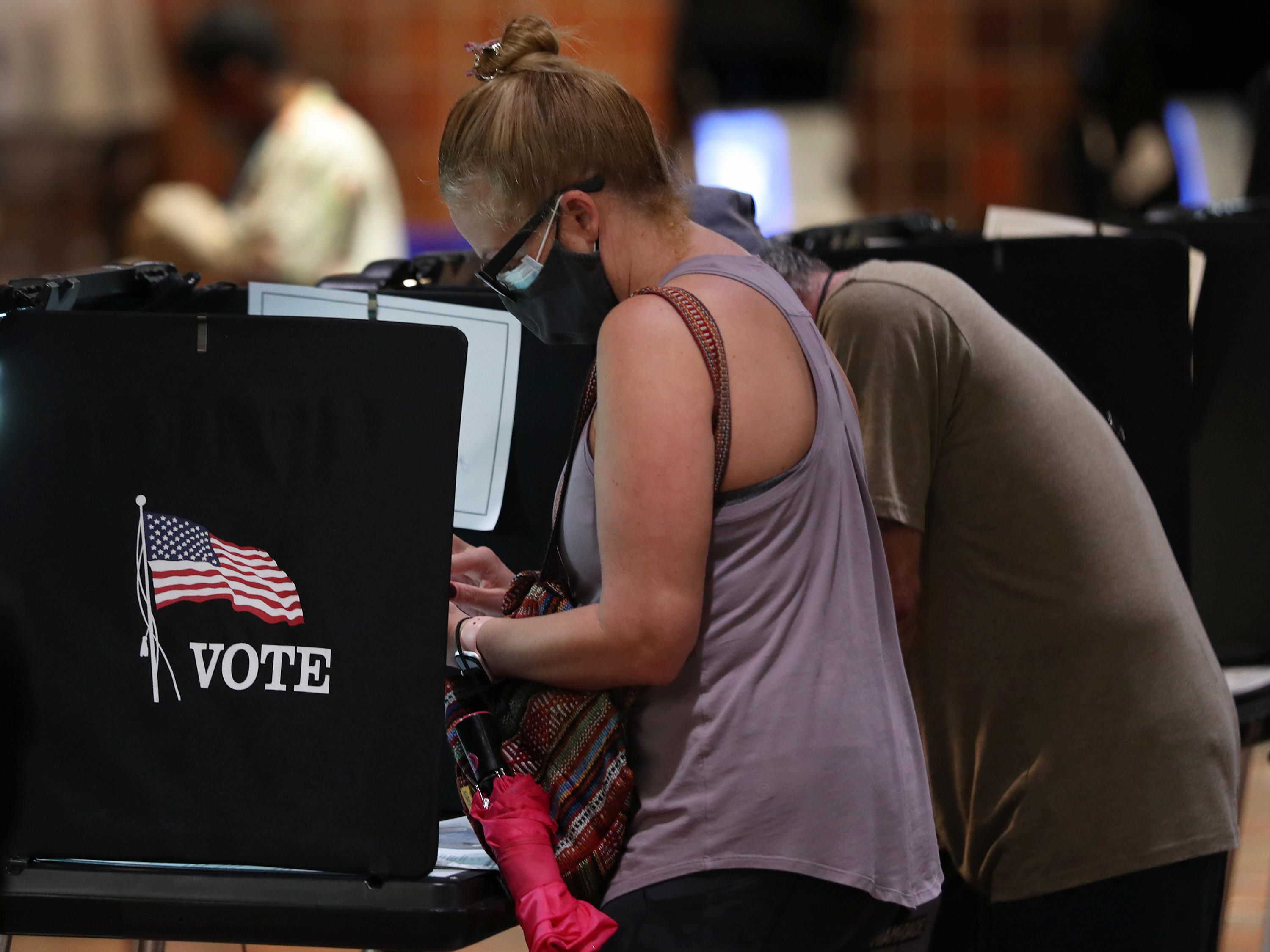 Voters fill out their ballots in Miami this week. Pandemic-driven changes to voting have led to a flood of disinformation about the election process. (Getty Images)