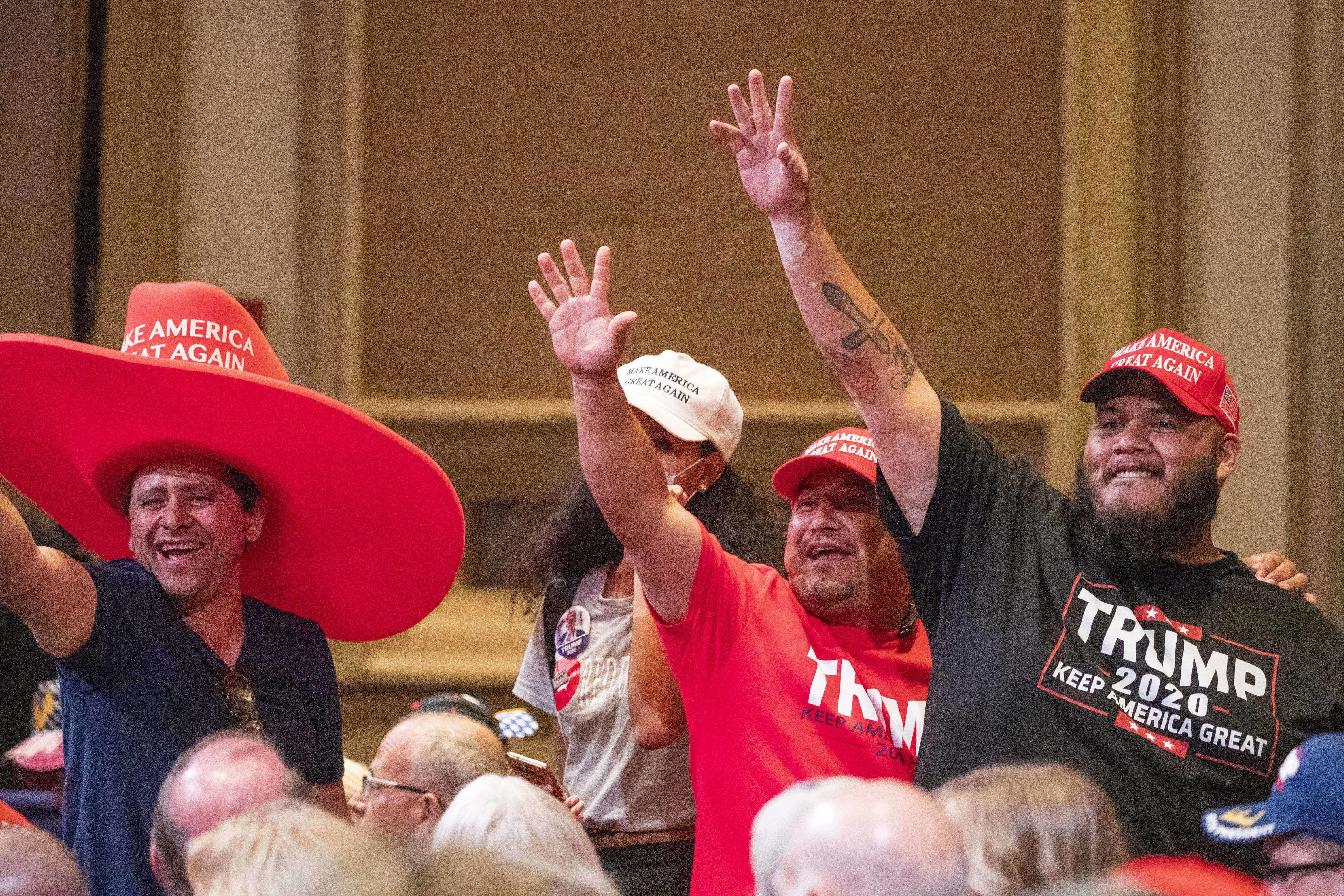 Supporters of President Trump wave during a Latinos for Trump roundtable last month at the Arizona Grand Resort in Phoenix. (USA Today Network via Reuters)