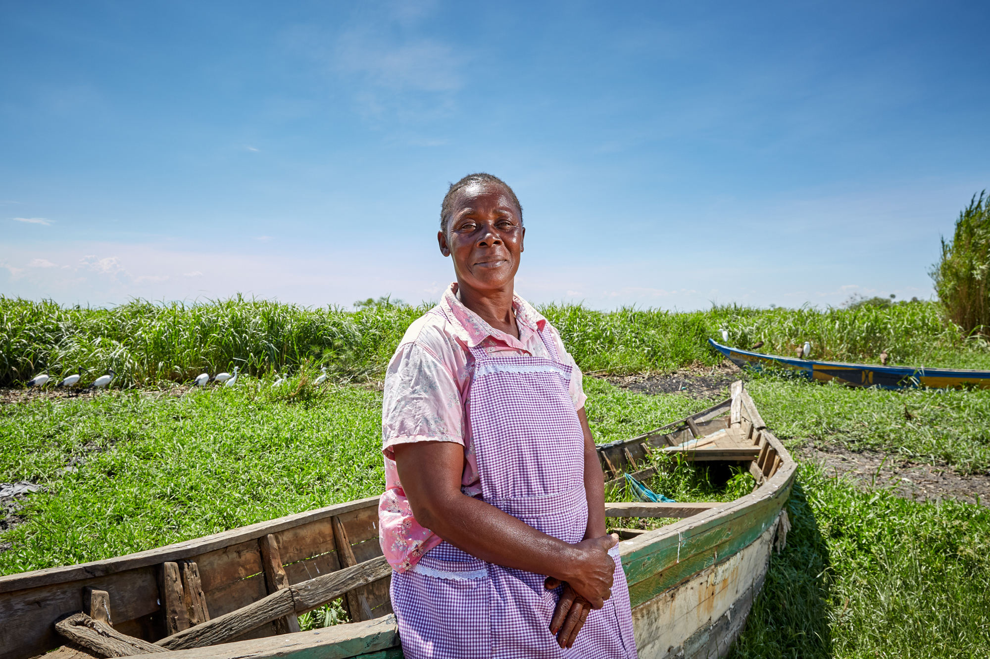 Alice Amonde sits on a boat on the village of Nduru Beach, Kenya. She is part of the group of women who have fought against the practice of transactional sex that was part of the fishing business. This photograph was taken in November 2019. This spring, flooding from Lake Victoria devastated the village. (Julia Gunther For NPR)