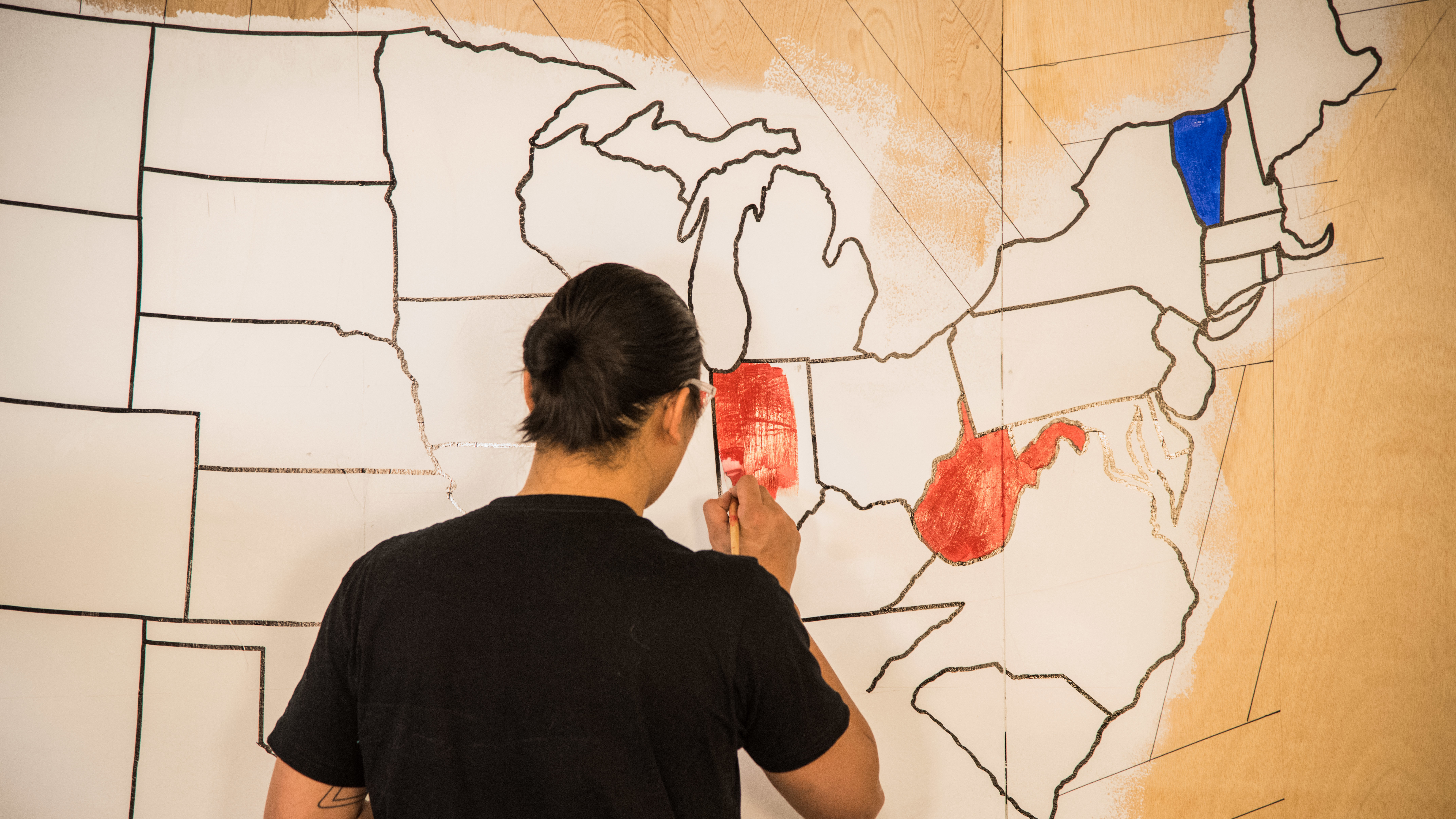 An artist paints a mural indicating which presidential candidate has won certain states on election night in 2016. Once again, NPR will rely on The Associated Press to provide election results and race calls. (NPR)