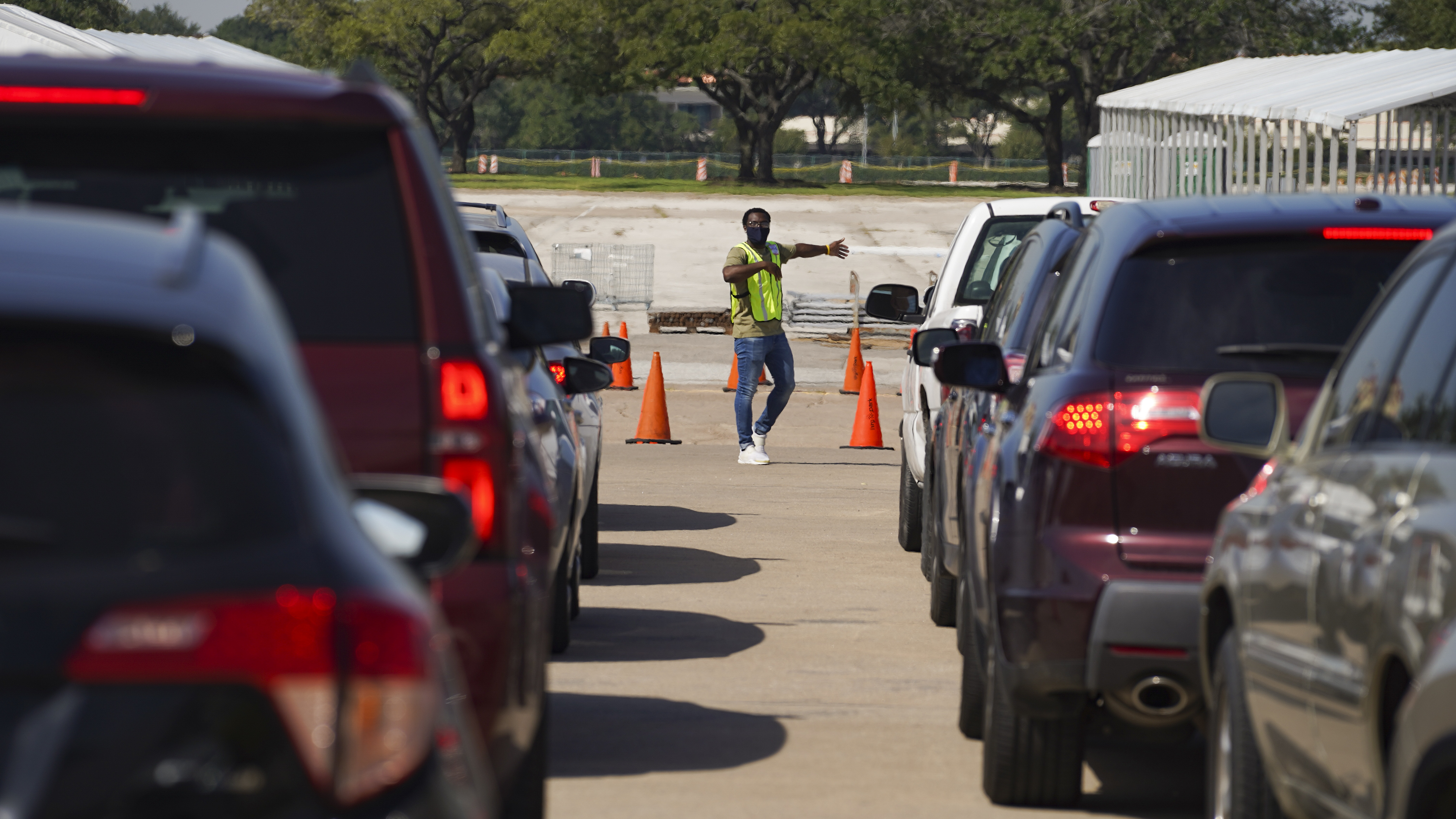 An election worker guides voters in cars at a drive-through voting site in Houston on Oct. 7. (Getty Images)