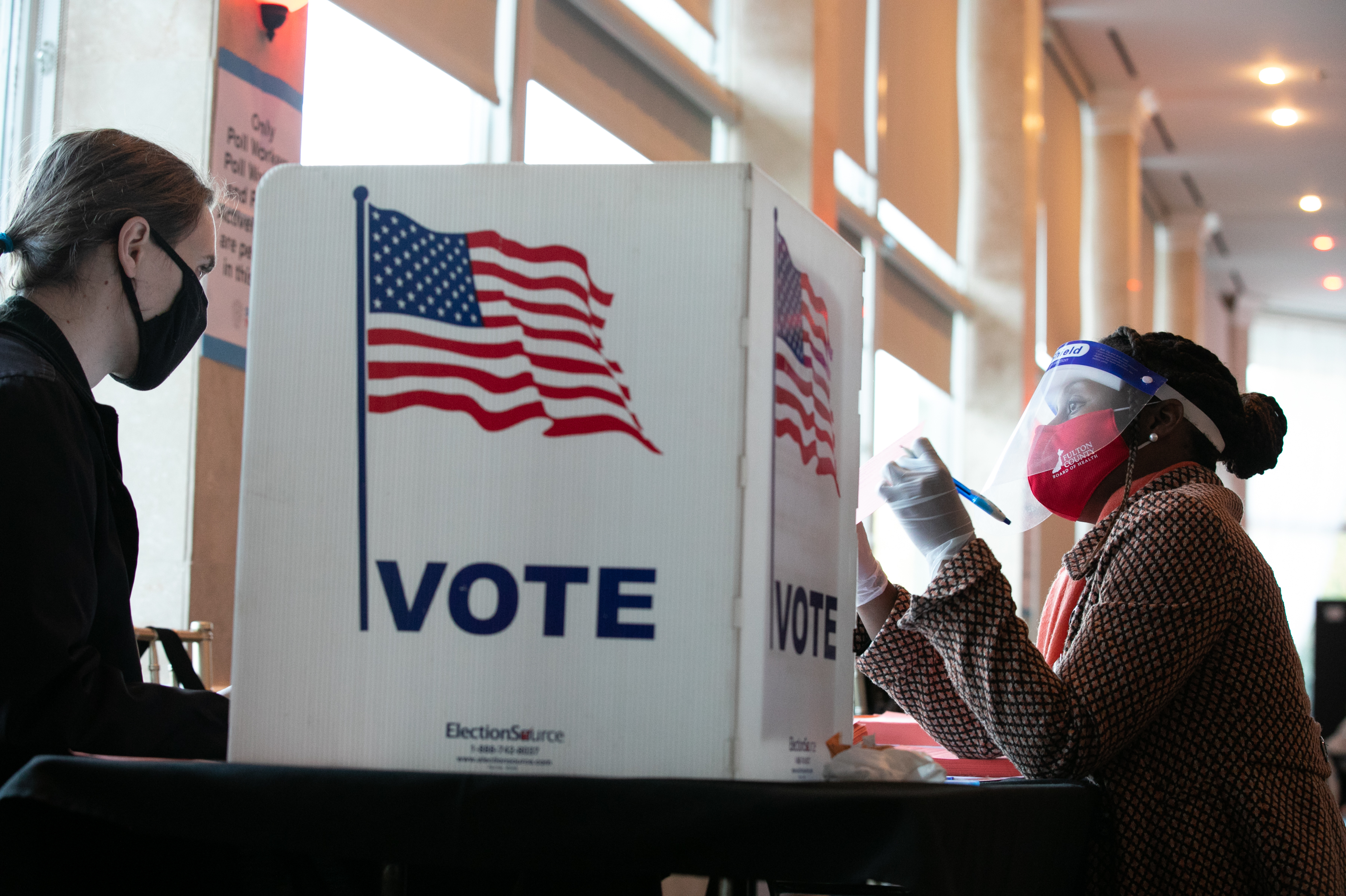 A poll worker helps K. Maki (left) fill out a provisional ballot at Park Tavern polling station on Tuesday in Atlanta, Ga. After a record-breaking early voting turnout, Americans head to the polls on the last day to cast their vote. (Getty Images)