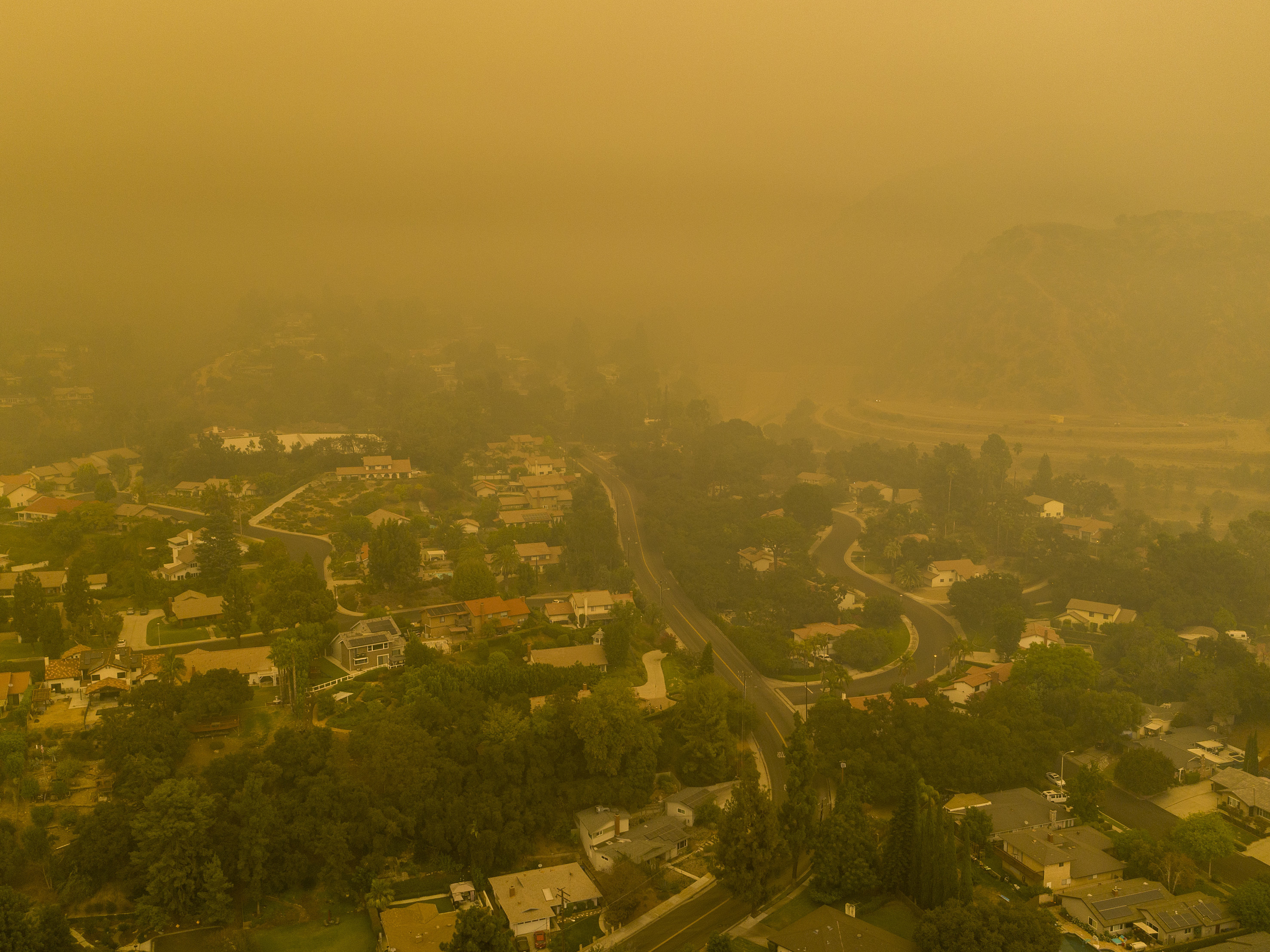 Climate change has been a key factor in increasing the risk and extent of wildfires and other catastrophic weather events. Here, an aerial view shows neighborhoods in Monrovia, Calif., shrouded in smoke from the Bobcat Fire in September. (Getty Images)