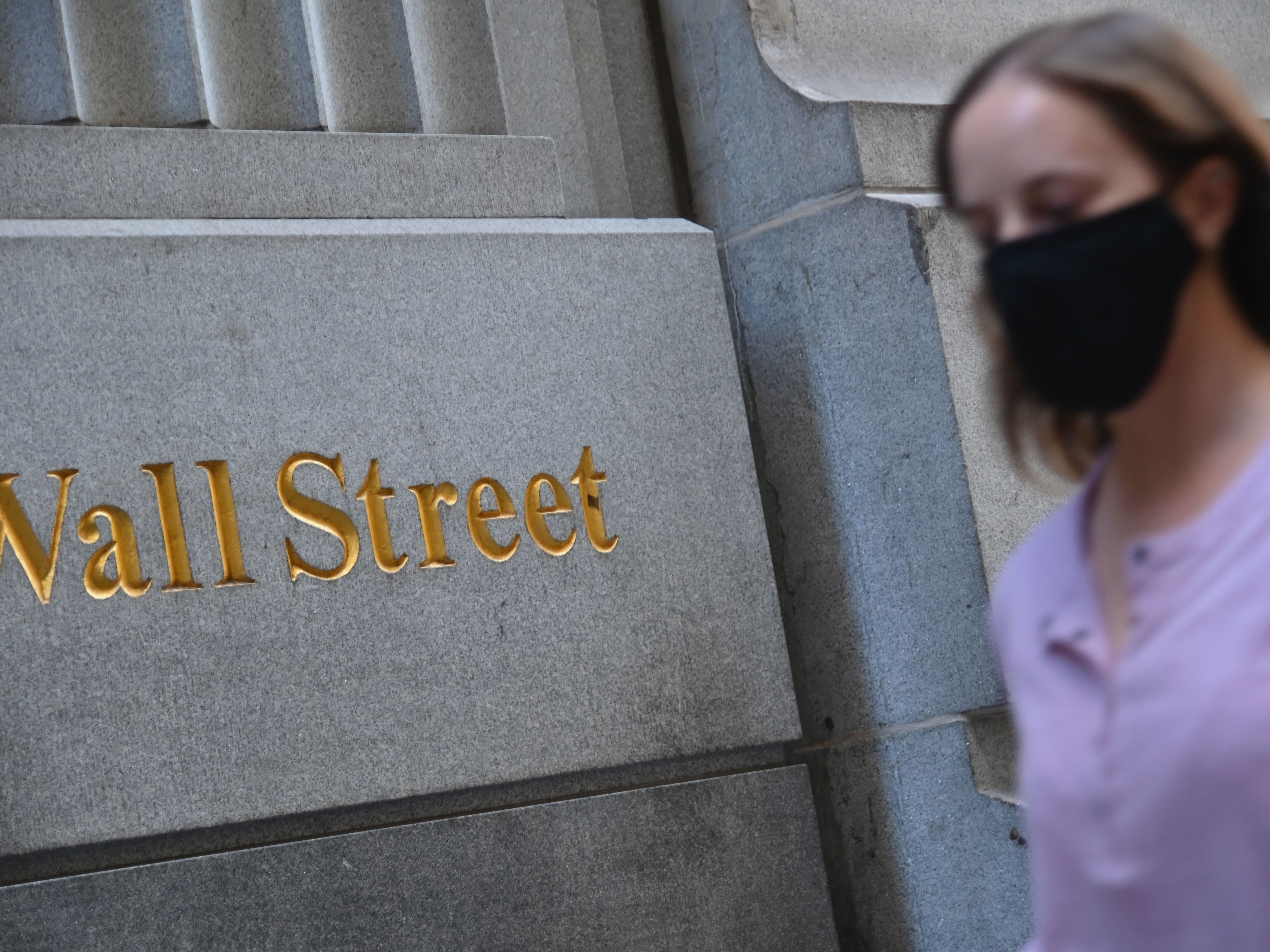 A woman walks by the New York Stock Exchange on Oct. 5. Stock markets are rallying at the prospect that this week's elections will result in a divided government. (AFP via Getty Images)