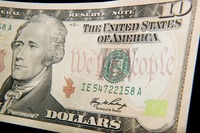 A close-up of the front of the US 10-dollar bill bearing the portrait of Alexander Hamilton, America's first Treasury Secretary.