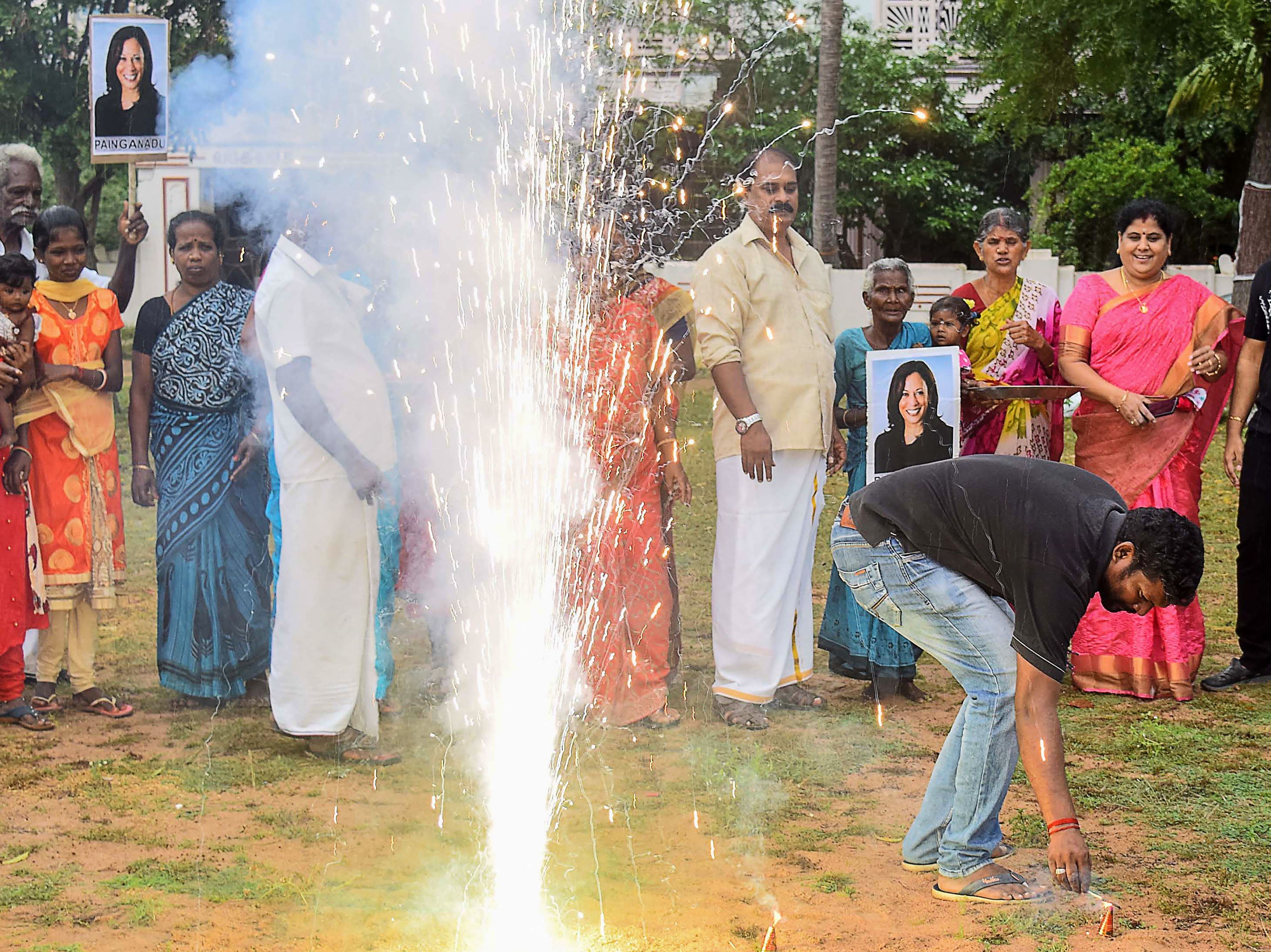 Residents hold placards with the portrait of of Vice President-elect Kamala Harris, as they celebrate her election victory in her ancestral village of Thulasendrapuram in the southern Indian state of Tamil Nadu on Saturday. (AFP via Getty Images)