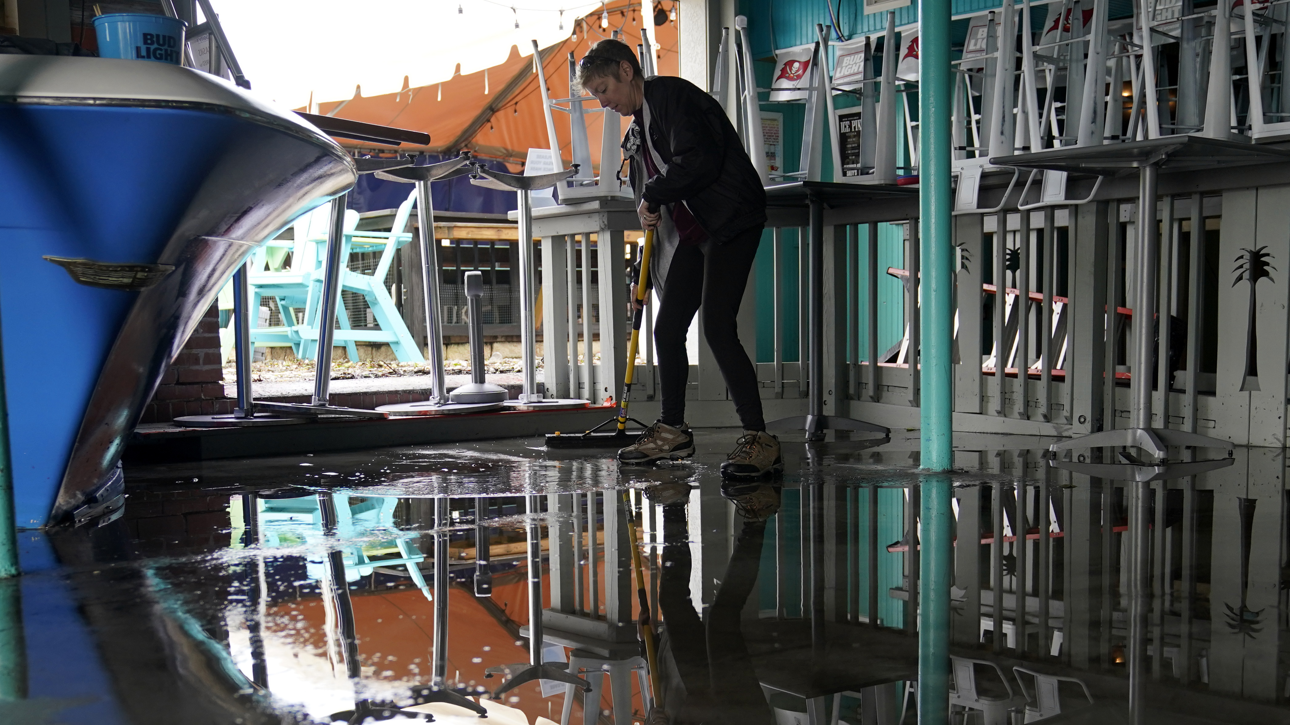 Kate Connell sweeps water and mud from the floor at Salty