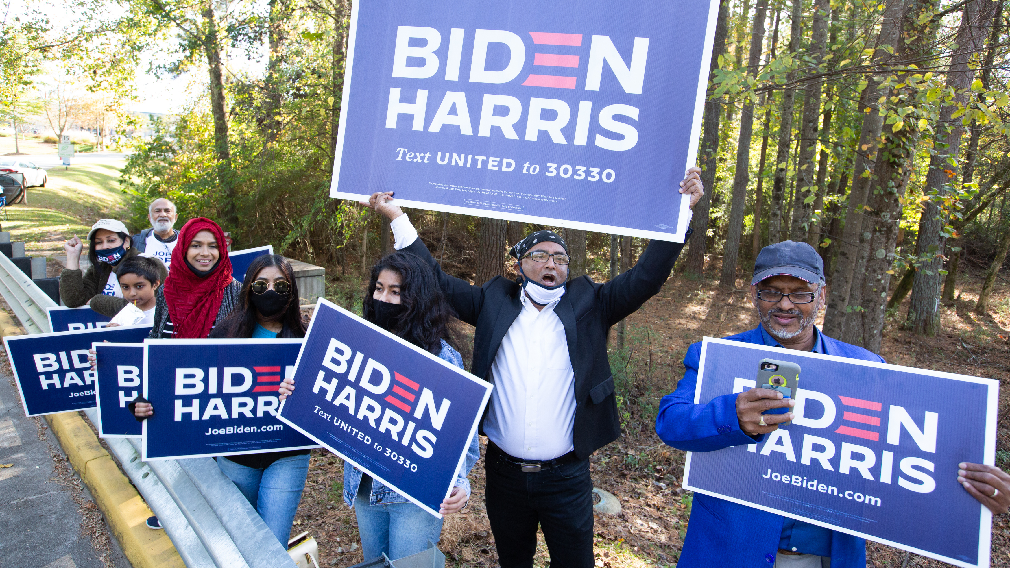 Residents of Gwinnett County in Georgia hold Biden-Harris campaign signs on Election Day in Norcross, Ga. President-elect Joe Biden ran up the margins in Atlanta's diversifying suburbs. (Getty Images)
