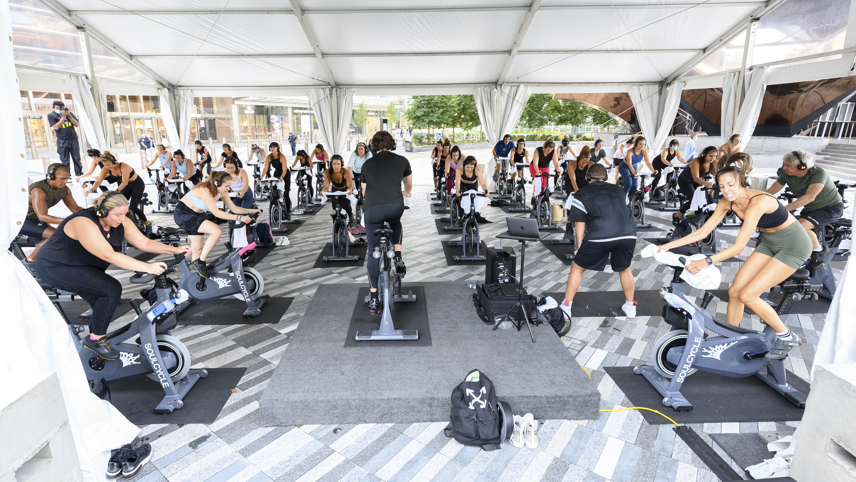 People attend an spin class under an outdoor tent in New York City.