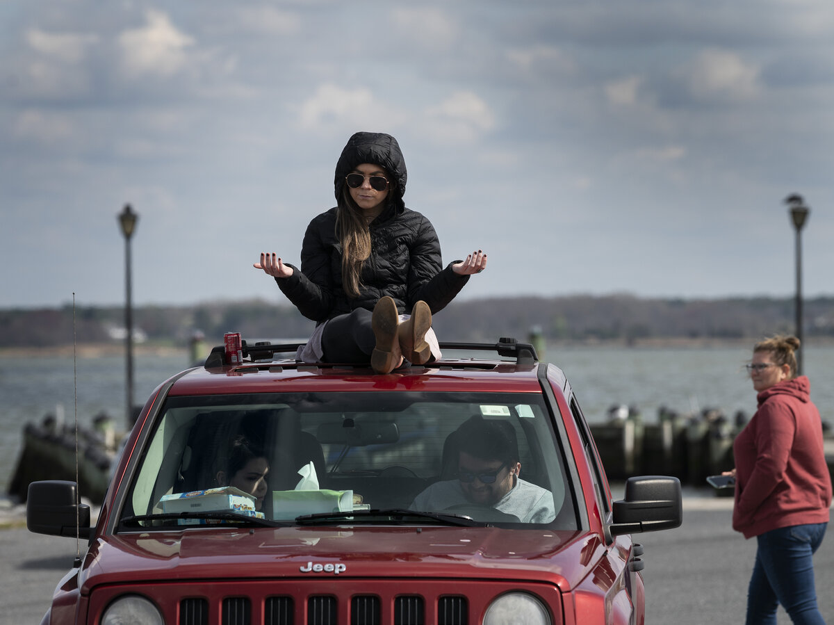 Member of Jesus Church prays on top of car