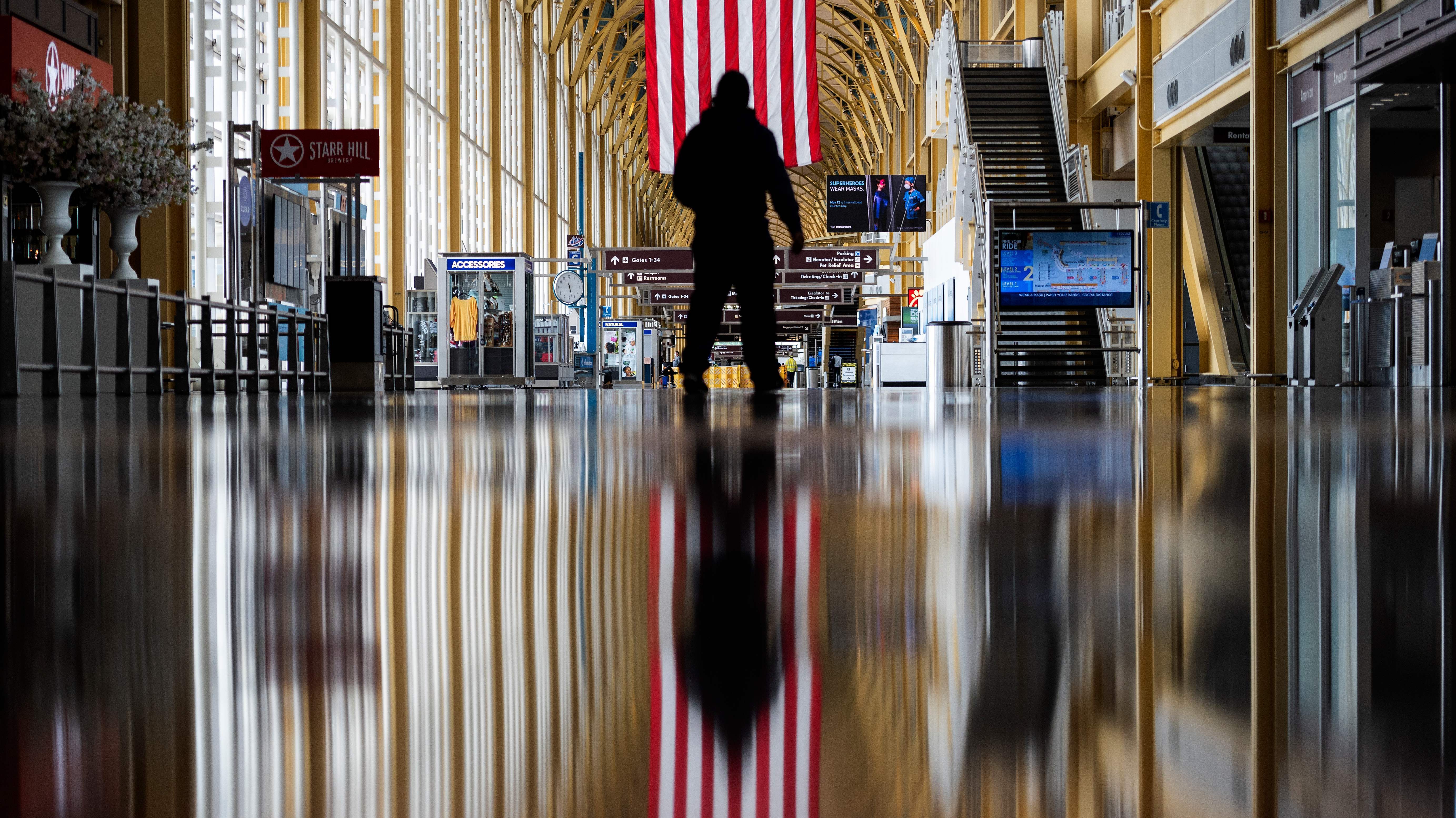 An airport employee walks through Reagan National Airport in Arlington, Va., earlier this year. On Thursday, the Centers for Disease Control and Prevention warned that Americans should refrain from traveling for the upcoming holiday. (AFP via Getty Images)