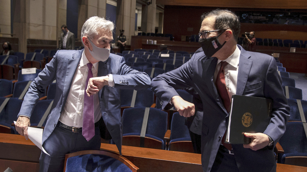 Fed Chairman Jerome Powell and Treasury Secretary Steven Mnuchin bump elbows at the conclusion of their testimony before Congress on June 30, 2020. The Fed and Treasury are engaging in a rare clash over the fate of key pandemic lending programs.