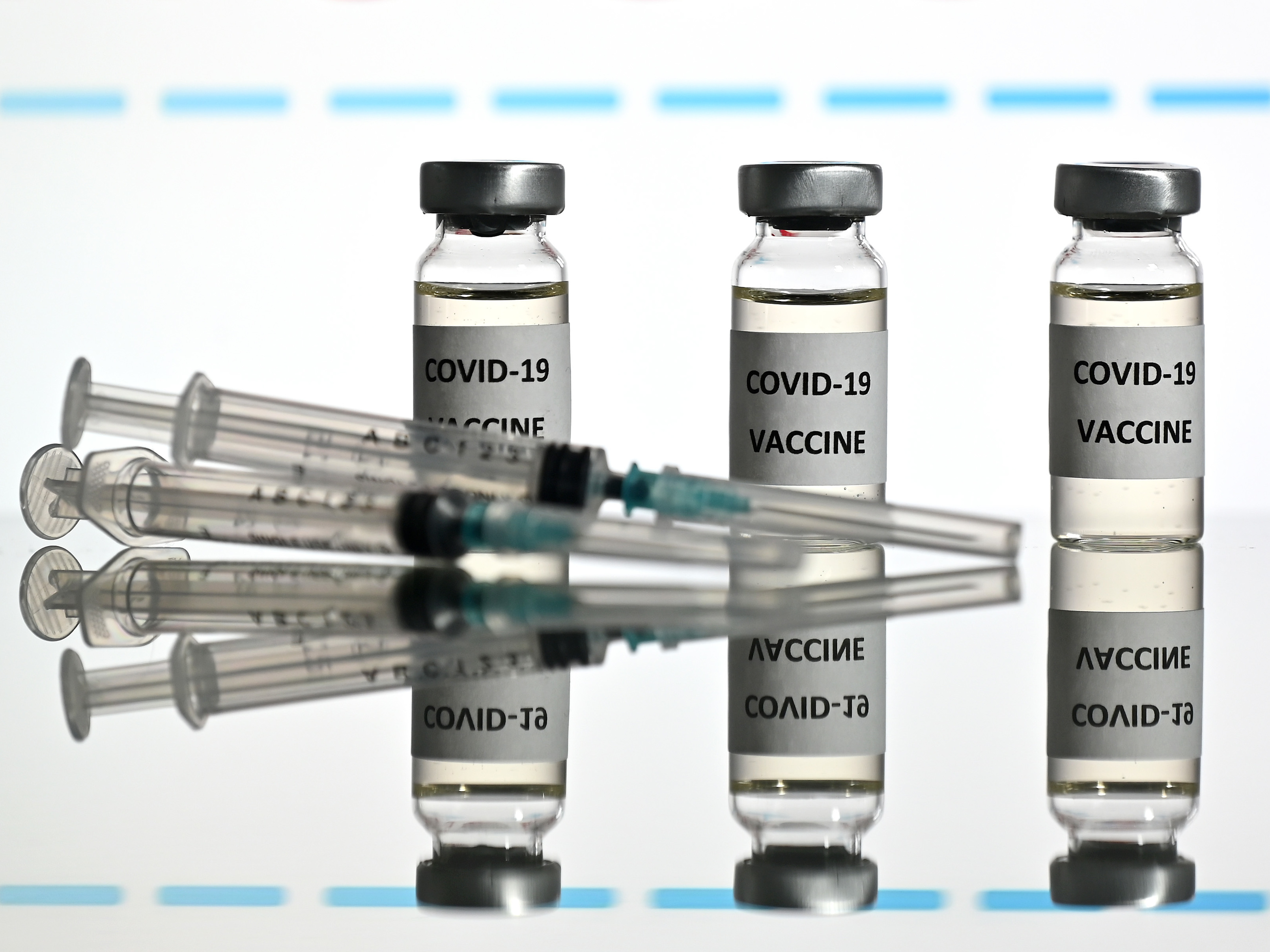 An illustration picture shows vials with COVID-19 vaccine stickers attached and syringes with the logo of U.S. biotechnology company Moderna on November 17. (AFP via Getty Images)