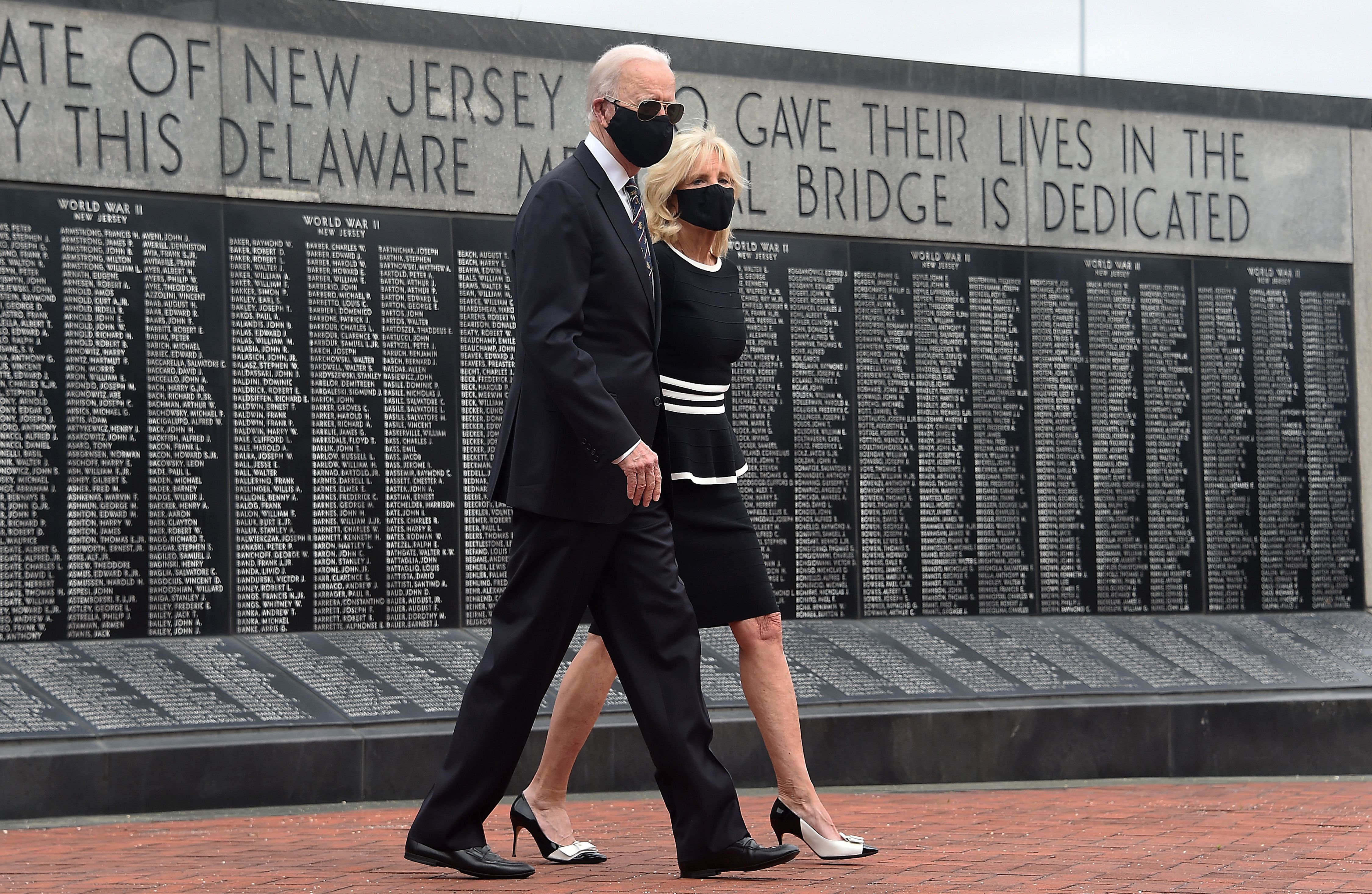 Joe Biden and his wife, Jill Biden, wear masks as they mark Memorial Day. The president-elect has consistently worn masks amid the pandemic, and he's already talking to governors about trying to implement a national mask mandate. (AFP via Getty Images)
