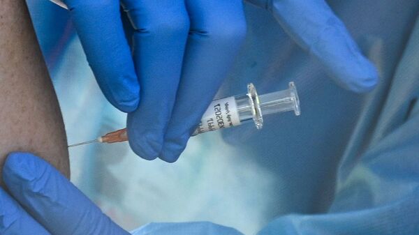A flu vaccine is administered at a walk-up COVID-19 testing sit in San Fernando, Calif. A COVID-19 vaccine could soon win emergency use authorization from the FDA.