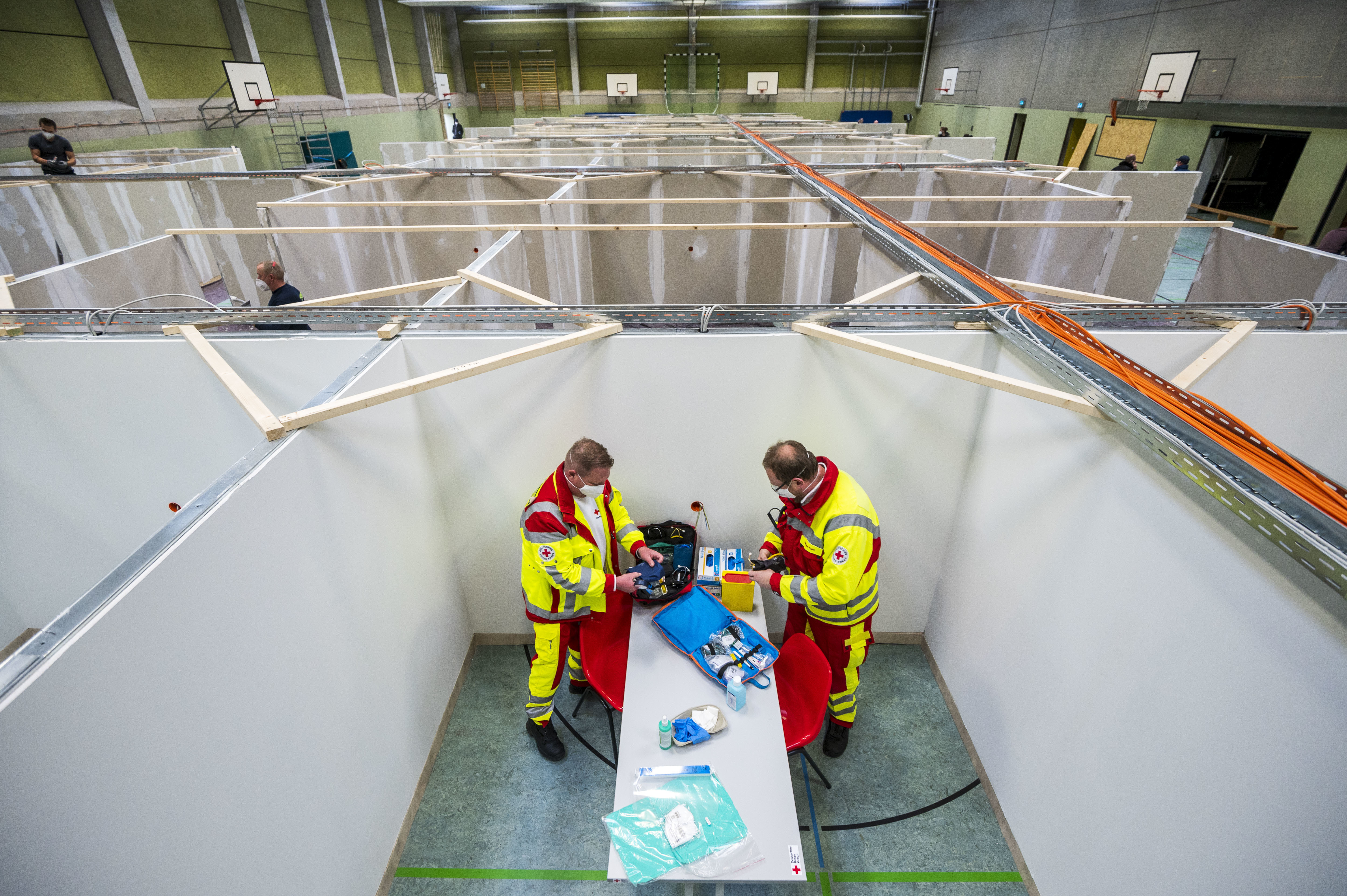The pending arrival of vaccines has brought &quot;hope for a brighter future,&quot; the OECD says. Here, workers from the Red Cross and the Federal Agency for Technical Relief help set up a center for COVID-19 vaccinations in a gymnasium in Eschwege, Germany. (Getty Images)