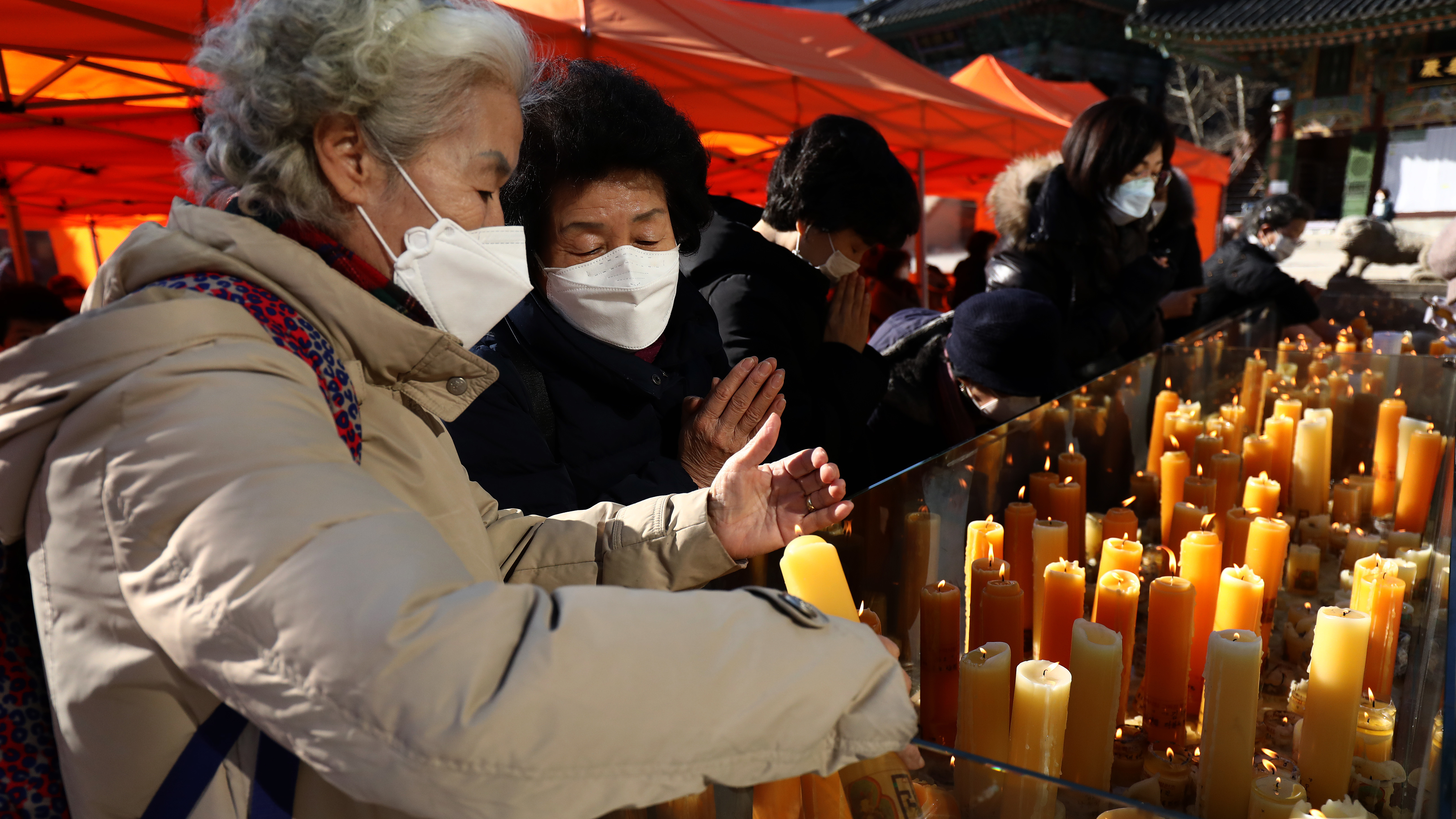 South Koreans pray for their children taking the College Scholastic Ability Test at Chogey temple, in Seoul on Thursday. New coronavirus infections in the country have spiked in recent days.